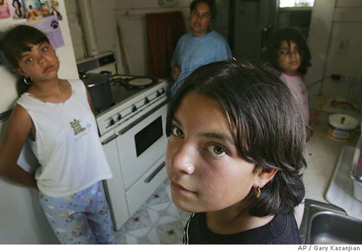 Maribel Cuevas looks on as her sister Lupita, far left, mother Guadalupe and sister Perla far right get ready for lunch Thursday, July 14, 2005 in Fresno, Calif. 11-year-old Cuevas faces a felony assault charge for throwing a rock at a boy and hitting him in the head after waterballoons were thrown at her. Cuevas spent several days in juvenile hall when police arrested her soon after the ambulance the family had called arrived.(AP Photo/Gary Kazanjian)