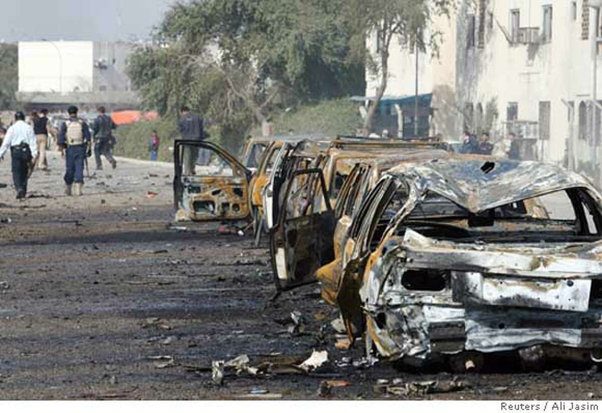 Burnt vehicles lie on a road after a car bomb attack in Baghdad February 5, 2007. The car bomb targeting a fuel station in the religiously mixed neighborhood of Saidiya in southern Baghdad killed 10 people and wounded 62, police said. REUTERS/Ali Jasim (IRAQ)