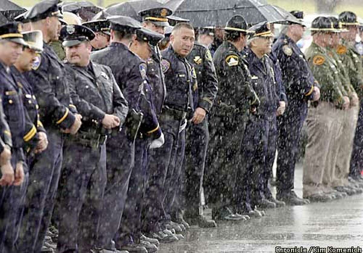 .jpg 4/21/03-Pittsburg, CA Officers from Bay Area agencies stood outside for several hours, at times in pouring rain. Funeral for Pittsburg Police Officer Raymond J. Giacomelli, who was murdered on April 15 while investigating a murder. Funeral at the Church of the Good Shepherd in Pittsburg Photo by Kim Komenich / The San Francisco Chronicle