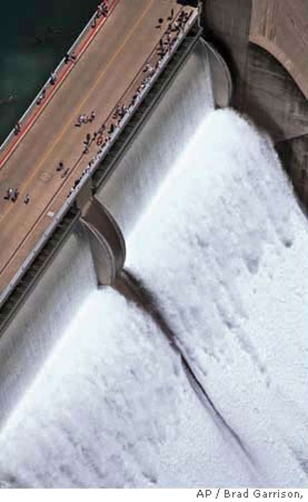 Thousands of people turned out in Lake Shasta, Calif., Thursday, June 18, 1998 to watch a man-made waterfall cascade over the lip of the Shasta Dam. About 1,200 cubic feet of water per second were allowed to slide over the top of the dam, a bare trickle at some waterfalls, but a roaring torrent when pouring over the entire length of the dam and crashing onto the spillway 500 feet below. The last time all three flashboard were opened was fifteen years ago. (AP Photo/Redding Record Searchlight, Brad Garrison) Ran on: 01-28-2007 Thousands turned out to watch a man-made waterfall at Shasta Dam as about 1,200 cubic feet of water per second were allowed to slide over the dam when all three flashboards were opened in 1998.
