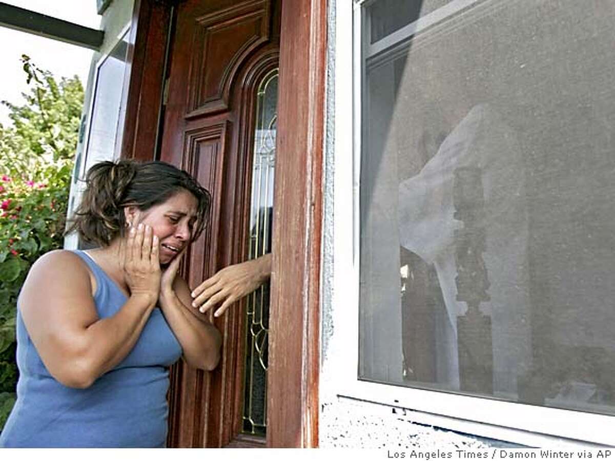 ** CORRECTS TO PENA STED LEMOS ** Lorena Lopez, wife of Jose Raul Pena, cries outside her home in South Los Angles Monday, July 11, 2005, as a family member reaches through the front doorway to comfort her. Pena and the couple's young daughter were shot and killed Sunday in a gun battle with police near his home. Pena apparently used his daughter as a shield during the standoff. (AP Photo/Los Angeles Times, Damon Winter) ** MANDATORY CREDIT: Damon Winter/Los Angeles Times, , NO FOREIGN, NO MAGS, TV OUT, LOS ANGELES DAILY NEWS OUT, ORANGE COUNTY REGISTER OUT, VENTURA COUNTY STAR OUT, INLAND VALLEY DAILY BULLETIN OUT, SAN BERNARDINO SUN OUT ** ** CORRECTS TO PENA STED LEMOS ** MANDATORY CREDIT: DAMON WINTER/LOS ANGELES TIMES, , NO FOREIGN, NO MAGS, TV OUT, LOS ANGELES DAILY NEWS OUT, ORANGE COUNTY REGISTER OUT, VENTURA COUNTY STAR OUT, INLAND VALLEY DAILY BULLETIN OUT, SAN BERNARDINO S