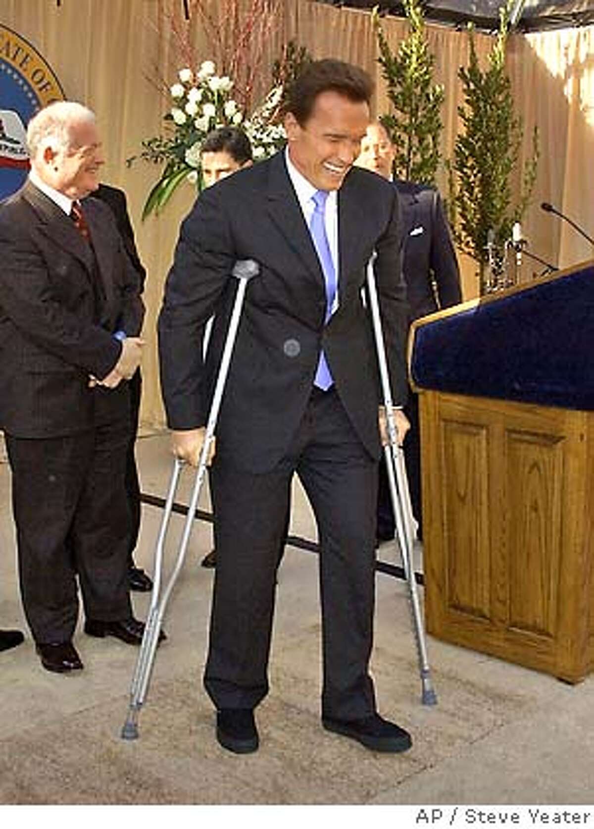 �Gov. Arnold Schwarzenegger's uses crutches to walk to his table after speaking at a a luncheon following his second inauguration in Sacramento, Calif., Friday, Jan. 5, 2006.(AP Photo/Steve Yeater,Pool)