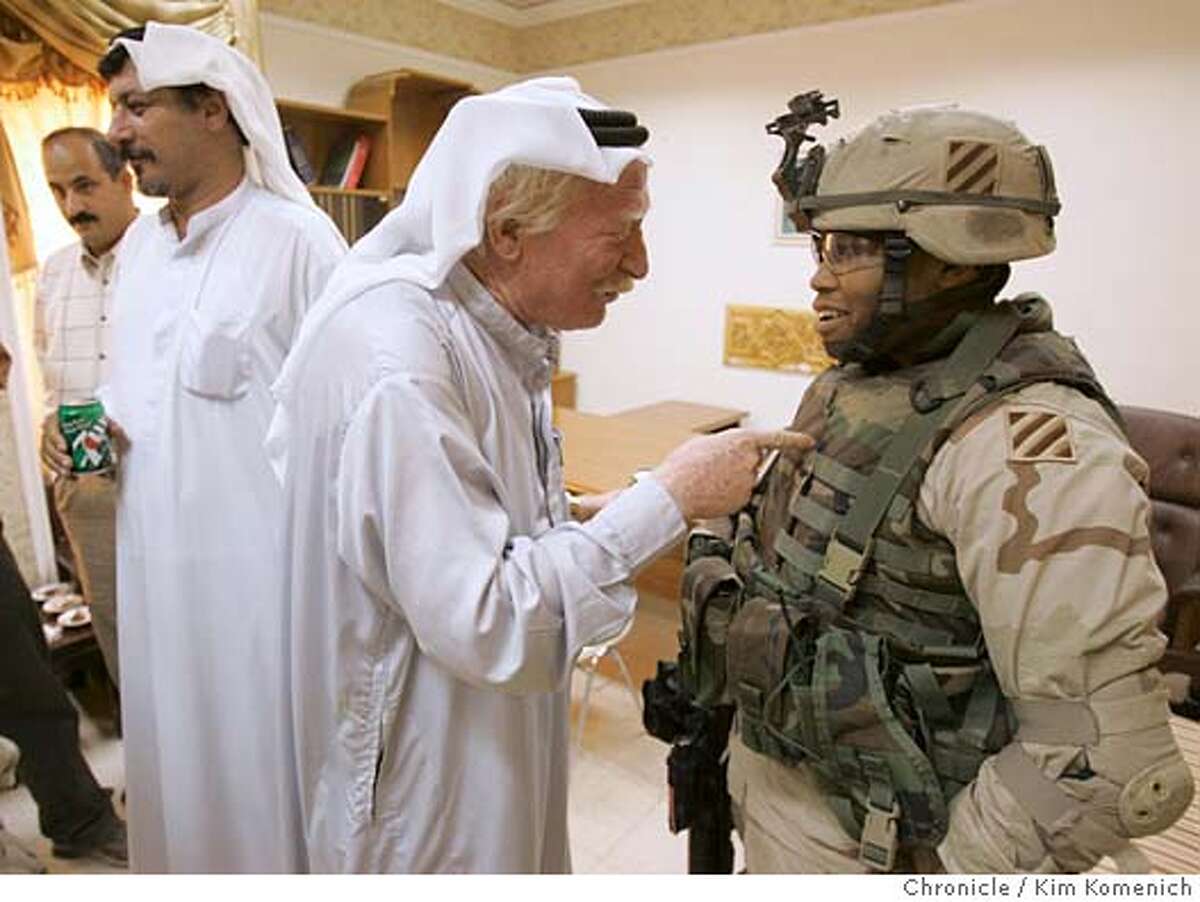 After a meeting spent hiring new hospital employees, Sheikh Ahmed Fahad Al Hazza, center, jokes with U.S. Army Lt. Ashley Garry (right, of Black platoon, Charlie company, 2-7 Infantry Battalion, 1st Brigade, 3rd Infantry.) He is the Army's liason to the Ajua area. Man at far left is not identified. Man second from left is Sheikh Thaad Al Hazza. We visit Auja Village (pop. 5,000, the hometown of Saddam Hussein. We visit a hospital that was originally built for Saddam and his family which is scheduled to open as a public hospital on June 26. San Francisco Chronicle photo by Kim Komenich