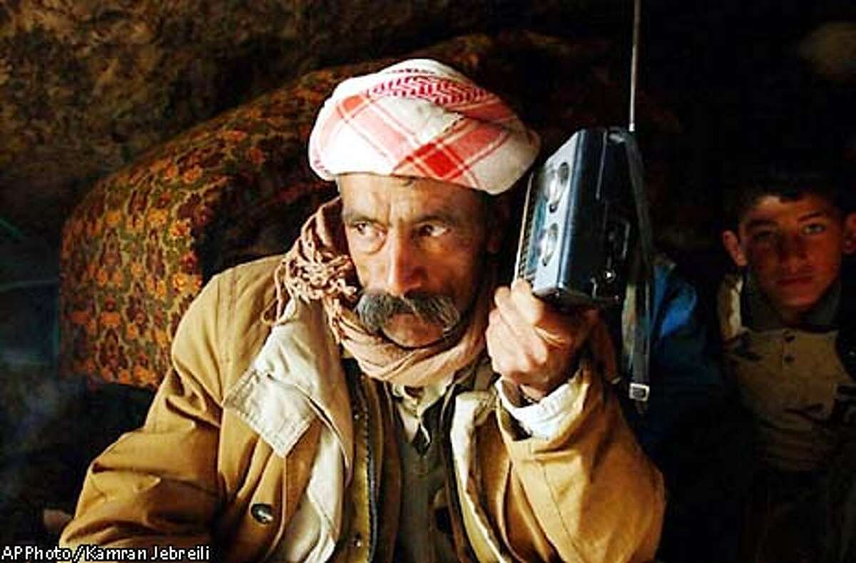 ** RETRANSMISSION OF XKJ107 FOR ALTERNATE CROP ** Iraqi-Kurd Khamoo Haji, 52, listens to a radio as he takes shelter inside a cave about 10 kilometers (6 miles) south of Dohuk, in Kurdish-controlled northern Iraq, Tuesday, March 25, 2003. Coalition warplanes landed in Kurdish territory Monday and launched airstrikes against barracks in northern Iraq, prompting frightened residents to flee the area. (AP Photo / Kamran Jebreili)