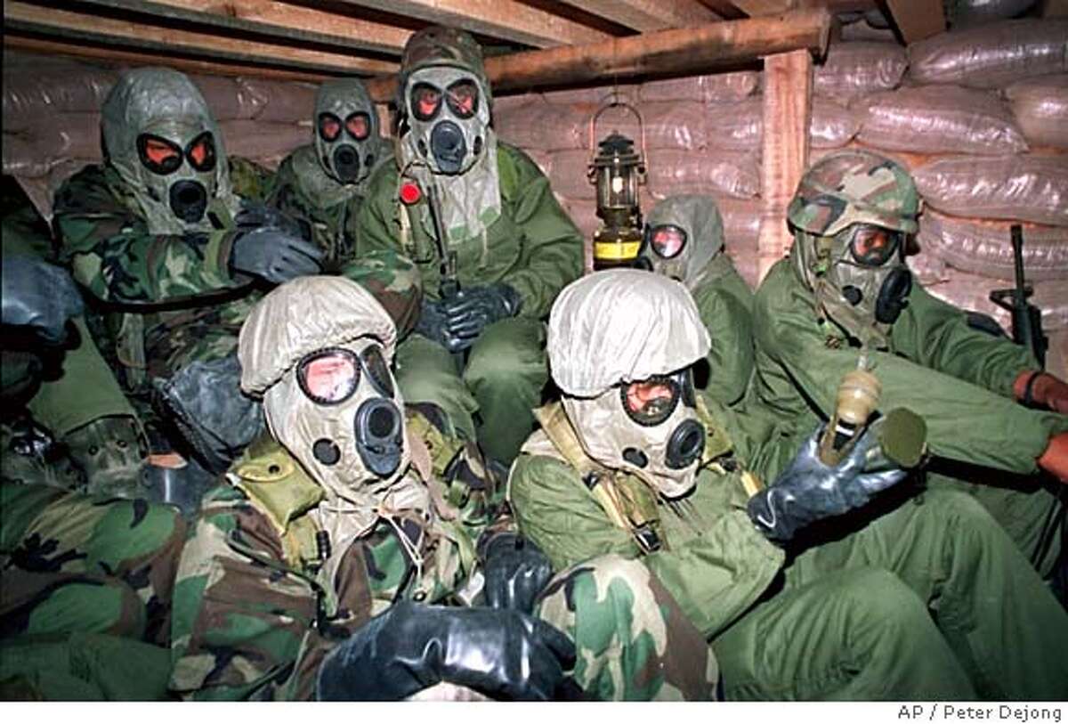 FILE--Soldiers with the U.S. army's 7th Corps huddle in a bunker in Eastern Saudi Arabia with gas masks and chemical suits just after U.S. planes started bombing Iraq in Jan. 18, 1991. (AP Photo/ Peter Dejong, Pool)