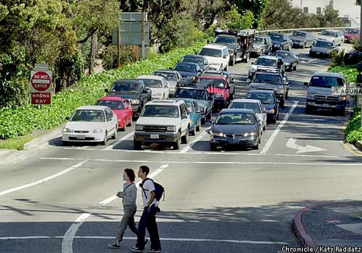 PHOTO BY KATY RADDATZ--THE CHRONICLE The Fell St. offramp of the Central Freeway will be demolished. SHOWN: A pair of pedestrians cross Fell St. as traffic waits to exit the offramp onto Fell St.