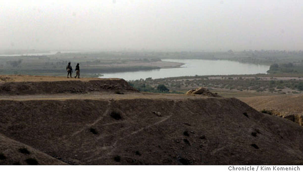 Lt. Col. Wood and Anna Badkhen walk on the bluffs. Lt. Col. Todd Wood of Battalion commander of the Army's 2-7 Infantry Battalion of the 1st Brigade, 3rd Infantry Division on a tour to the "Northern Outlook" on bluffs north of Qadessiya, which overlook the TIgris River. We then visit some villages where soldiers distribute toys. At one of the villages some unexploded munitions are discovered. Our group guards the explosives until they are relieved. San Francisco Chronicle photo by Kim Komenich San Francisco Chronicle photo by Kim Komenich
