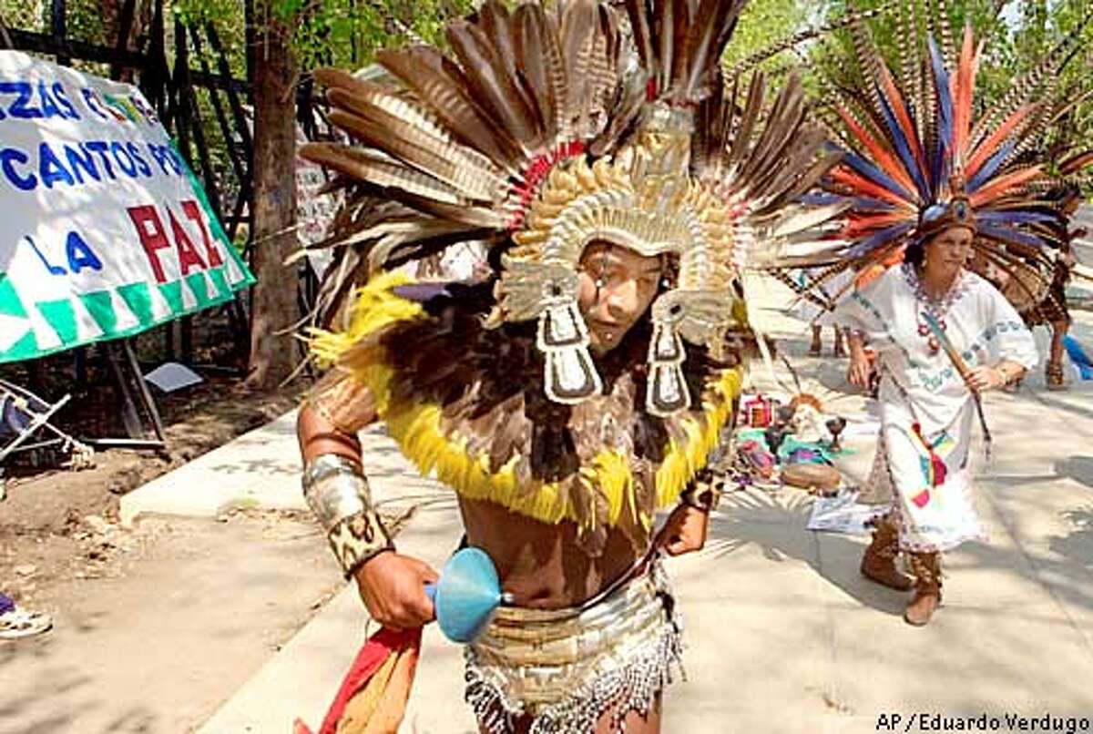 Dancers dressed as Azteca Indians perform outside of the U.S. embassy in Mexico City Feb. 25, 2003, against a possible U.S.-led war with Iraq. (AP Photo/Eduardo Verdugo)