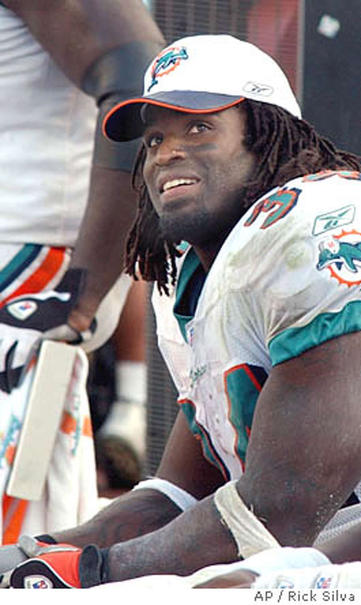 Miami Dolphins' running back Ricky Williams smiles as he looks up at the scoreboard during a game against the San Diego Chargers Sunday, Nov. 24, 2002 in Miami. Williams finished the day with 143 yards on 29 carries giving him over 1000 yards for the season. This was the sixth game of the year where Williams has gained over 100 yards. (AP Photo/Rick Silva)