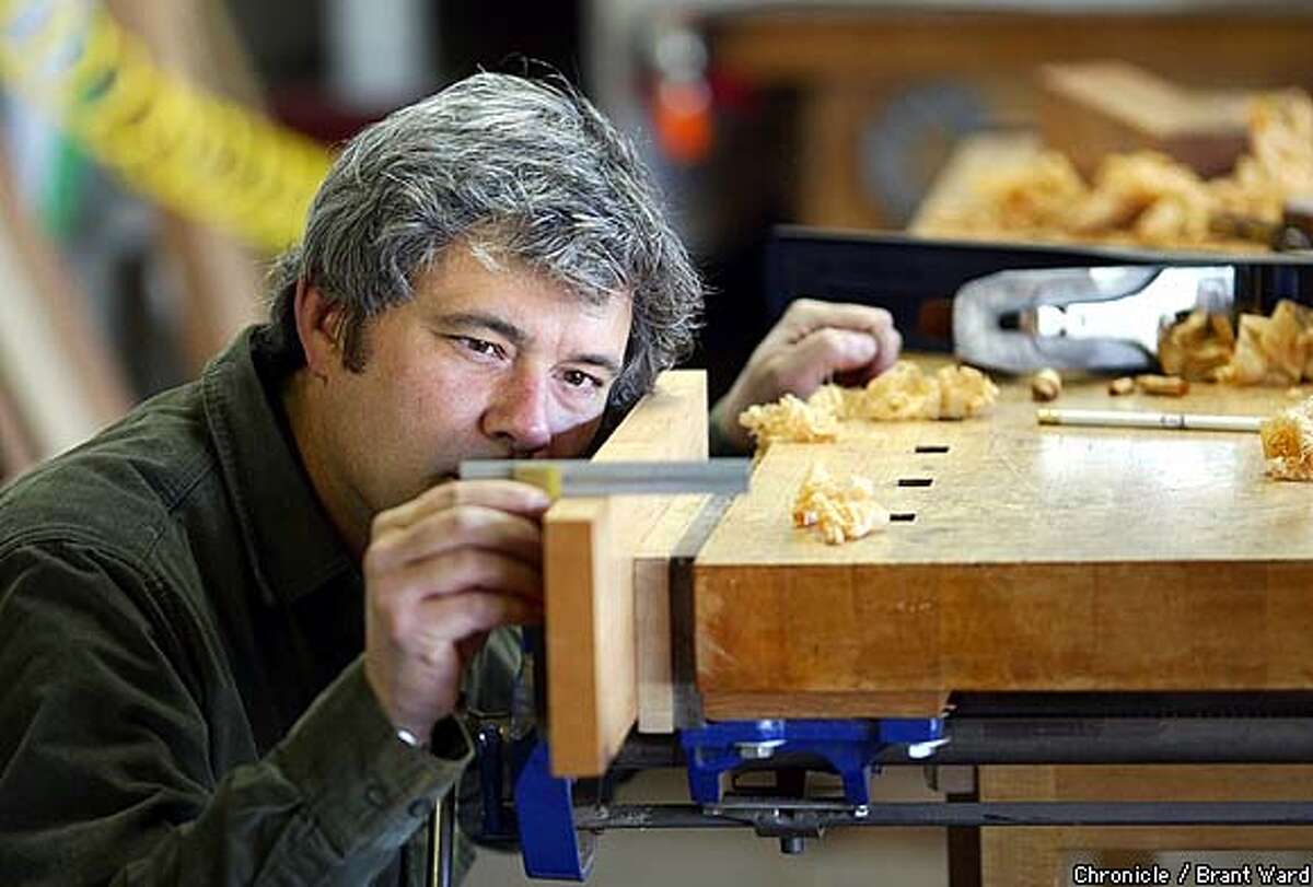 Master wood craftsman Michael Cullen checks out the flatness of a piece of wood in his Petaluma studio...he is currently teaching David Hirsch the intricasies of woodworking. By Brant Ward/Chronicle