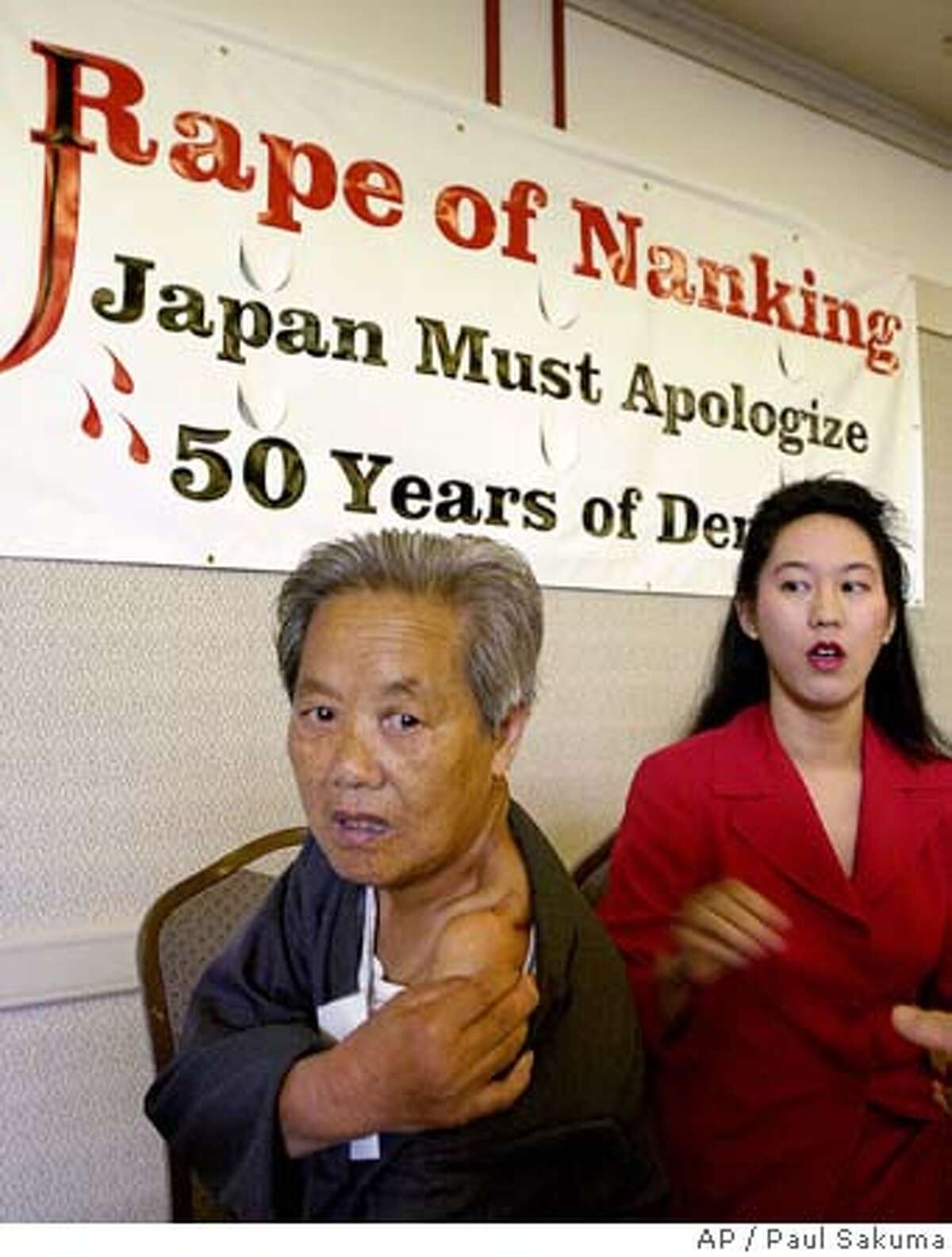 ** FILE ** Cuiping Ni, 75, shows off her scar as Iris Chang, right, author of "The Rape of Nanking," looks on during the opening of the conference, "50 Year of Denial: Japan and Its Wartime Responsibilities," in San Francisco, Friday, Sept. 7, 2001. Chang, a best-selling author who chronicled the Japanese occupation of China and the history of Chinese immigrants in the United States, has died of a self-inflicted gunshot at age 36. The official cause of death has not been released, but investigators concluded that Chang shot herself in the head, officials said. She lived in San Jose with her husband, Brett Douglas, and their 2-year-old son, Christopher. (AP Photo/Paul Sakuma) Metro#MainNews#Chronicle#11/12/2004#ALL#5star##0422460885