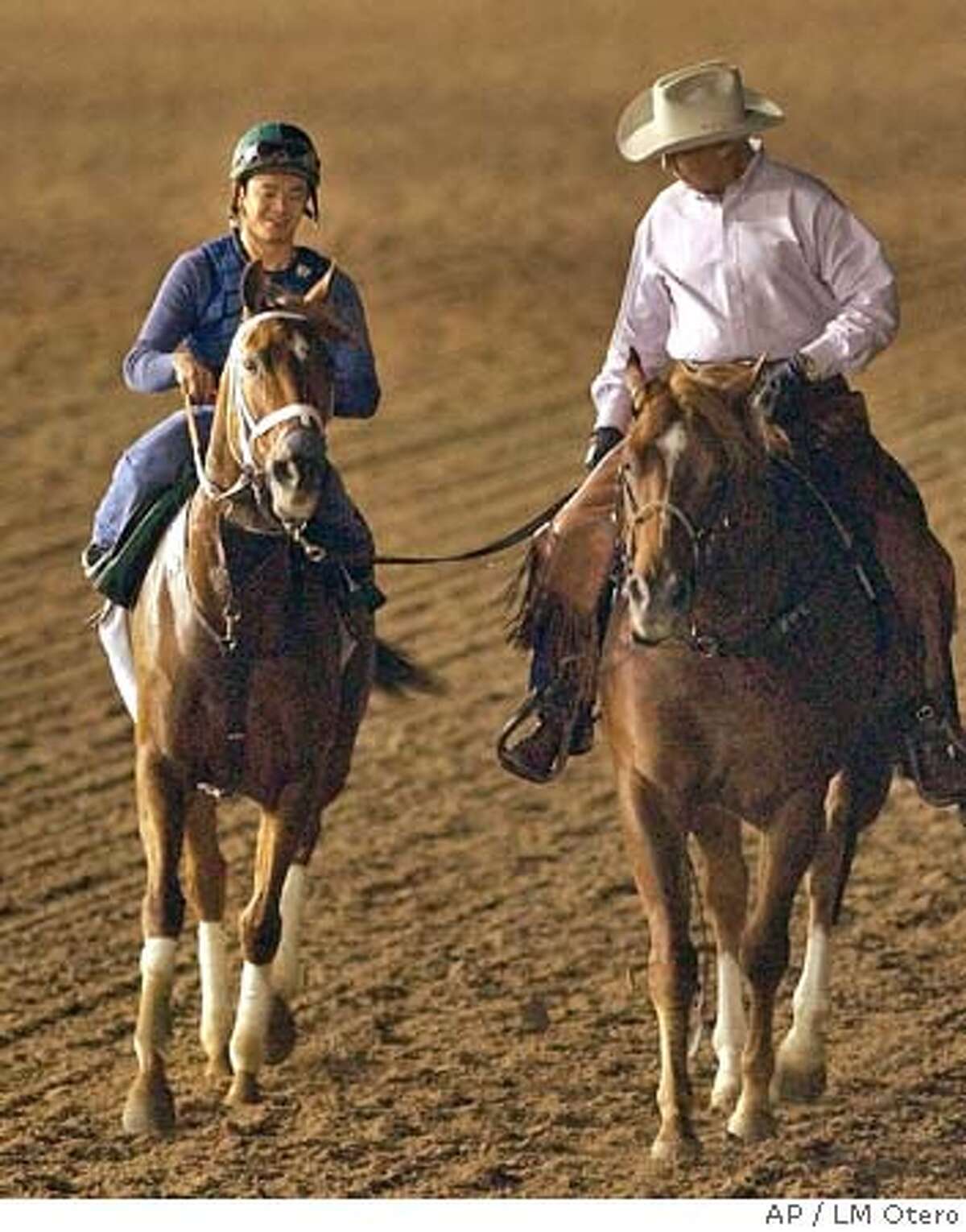Azeri, left, topped by practice rider Yutta C.T. Lang is led by trainer D. Wayne Lukas, right, during an early morning workout at Lone Star Park Friday, Oct. 29, 2004, in preparation for Saturday's Breeders' Cup race in Grand Prairie, Texas. (AP Photo/LM Otero) Sports#Sports#Chronicle#10/30/2004#ALL#5star##0422439320
