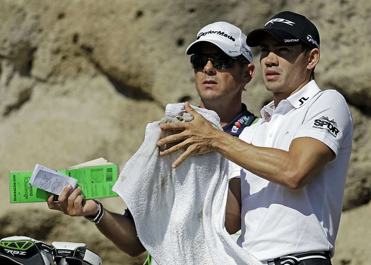 Camilo Villegas, right, wipes his hands on the third hole of the Jack Nicklaus Private Course at PGA West during the first round of the Humana Challenge PGA golf tournament, Thursday, Jan. 19, 2012, in La Quinta, Calif. (AP Photo/Ben Margot)