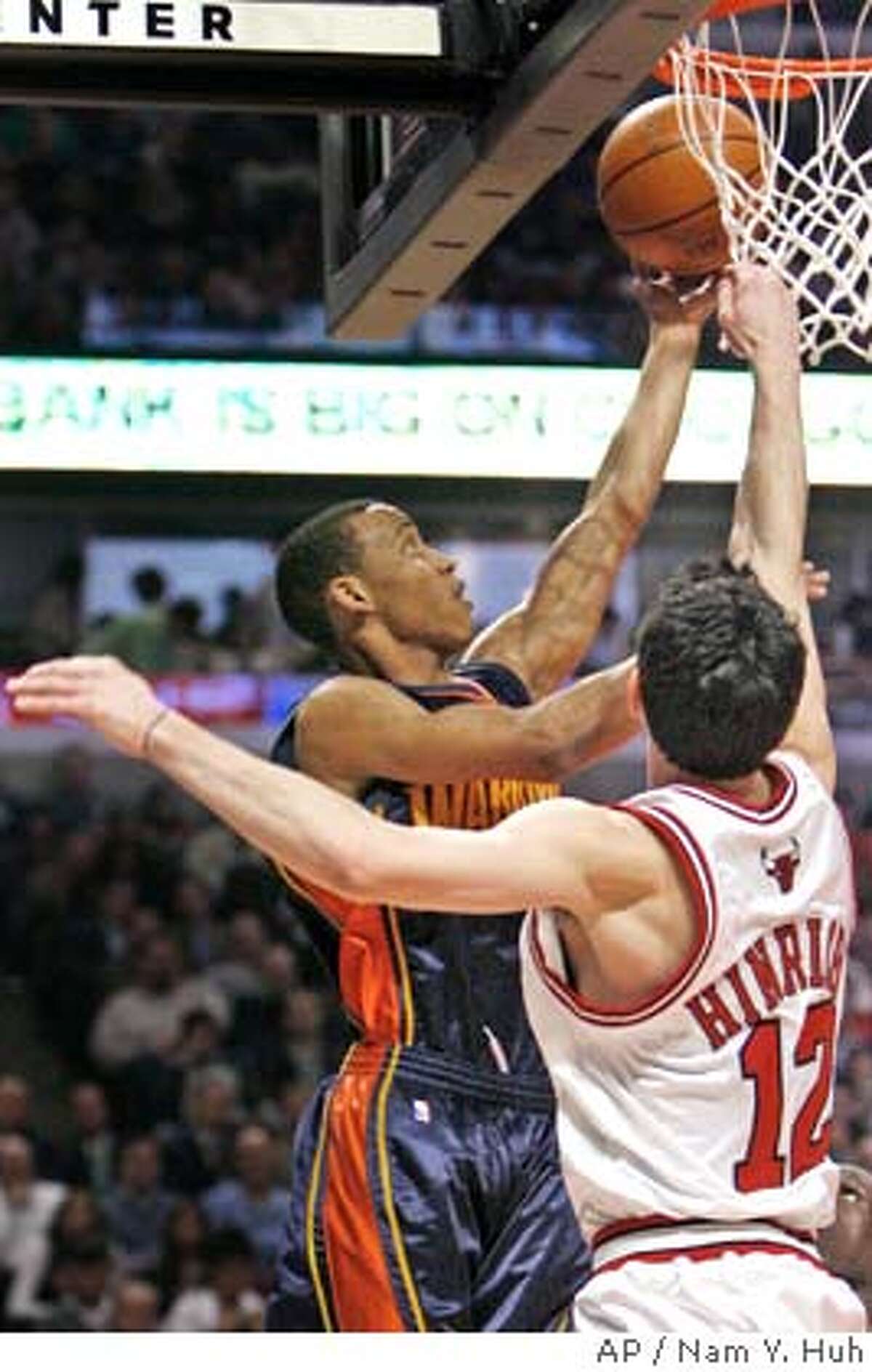 Golden State Warriors guard Monta Ellis, left, goes up for a shot against Chicago Bulls' Kirk Hinrich during the first quarter of an NBA basketball game in Chicago, Wednesday, Feb. 28, 2007.(AP Photo/Nam Y. Huh)