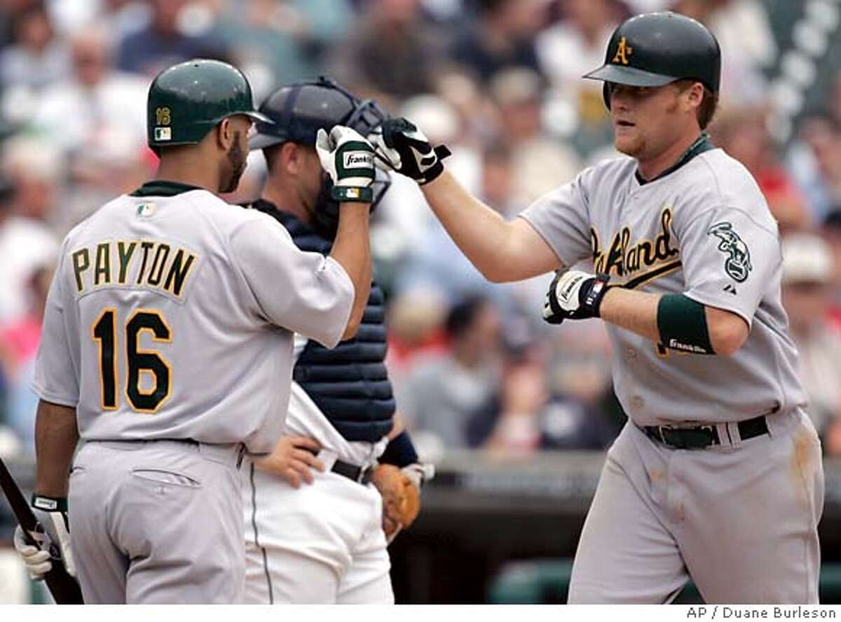 Oakland Athletics' Dan Johnson, right, is congratulated by Jay Payton (16) after his solo home run in the fifth inning Thursday, Aug. 25, 2005, in Detroit. The Athletics beat the Tigers, 11-1. (AP Photo/Duane Burleson)