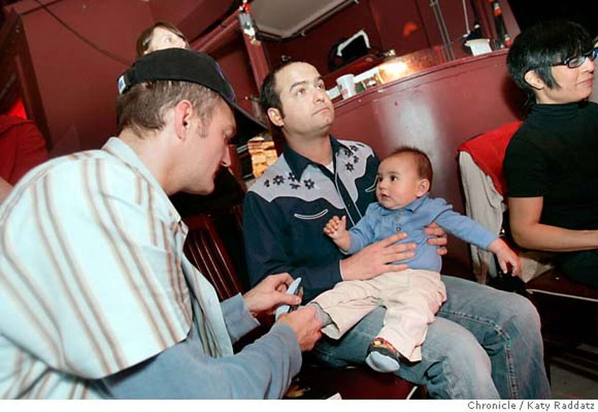 ALTERNADADxx_021_RAD.jpg SHOWN: Neal Pollack (far right) holds 6-mo-old Marcos Tolliver on his lap while Marcos' dad, Greg Tolliver (L), puts Marcos' sock on straight. Neal Pollack wrote the book, "Alternadad," about trying to stay hip after having a child. Neal reads from the book and signs the book at 12 Galaxies in the Mission District, while parents and kids gather to enjoy the band, who are calling themselves "The Timeouts." These pictures were made on Sunday, Jan. 28, 2007, in San Francisco, CA. For POLLACK18 Style section (KATY RADDATZ/SFCHRONICLE) **Neal Pollack, Marcos Tolliver, Greg Tolliver Mandatory credit for the photographer and the San Francisco Chronicle. No sales; mags out.