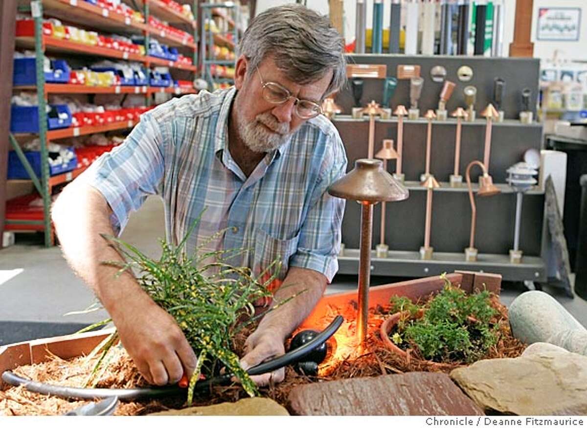 Tom Bressan, co-founder of Urban Farmer in Richmond, installs a drip irrigation system in the in-store display. San Francisco Chronicle/ Deanne Fitzmaurice