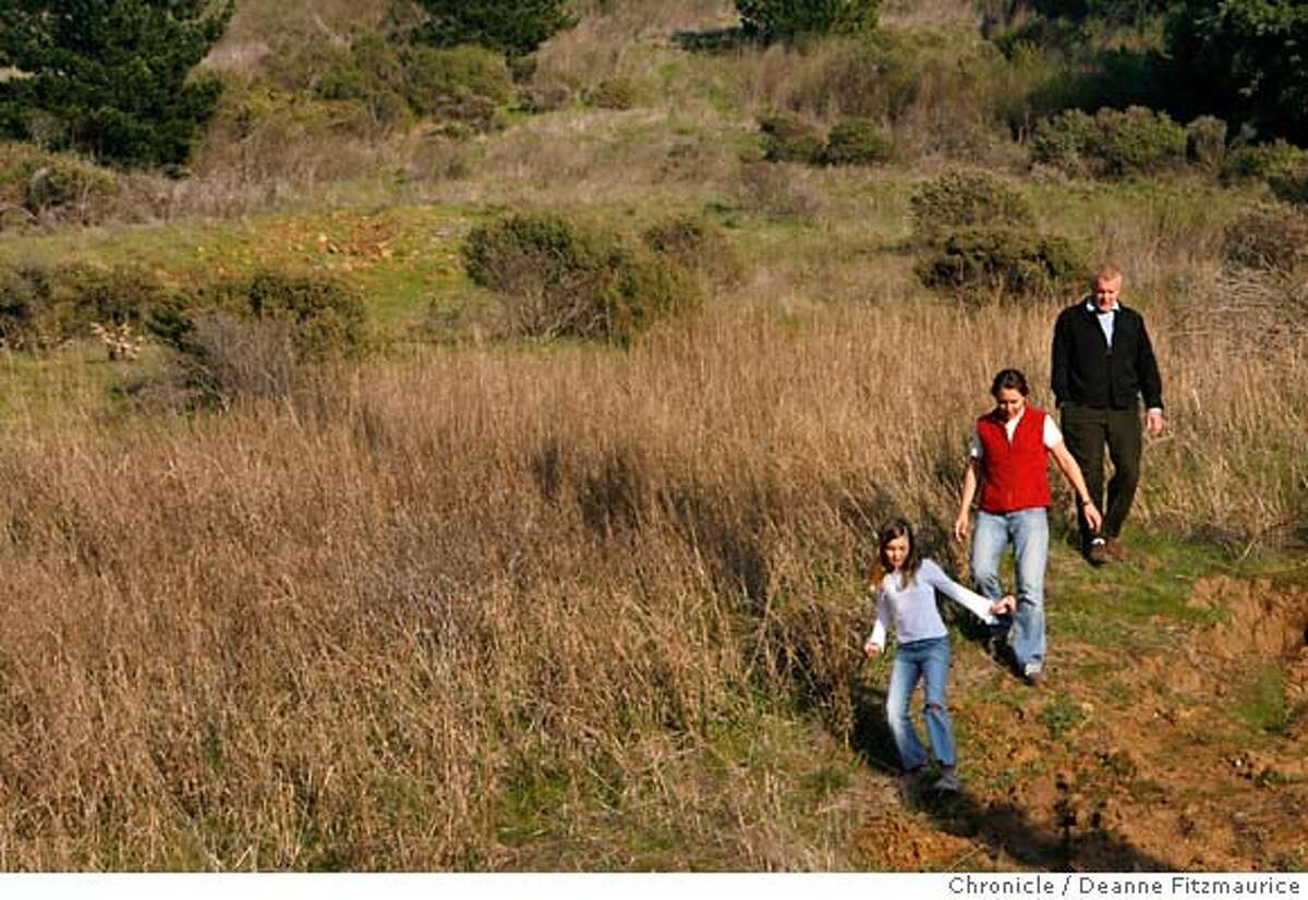 habitat24_0089_df.jpg From top, Bill Duane, his wife, Elke (cq), and daughter Diana, 8, show Chronicle reporters a hillside near their home which is targeted for new development. They are opposed to a development proposed in unincorporated Mill Valley which will include four low income homes built by Habitat for Humanity, and three large homes on this hillside. Photographed in Mill Valley on 1/23/07. Chronicle Photo / Deanne Fitzmaurice Mandatory credit for photographer and San Francisco Chronicle. /Magazines out.