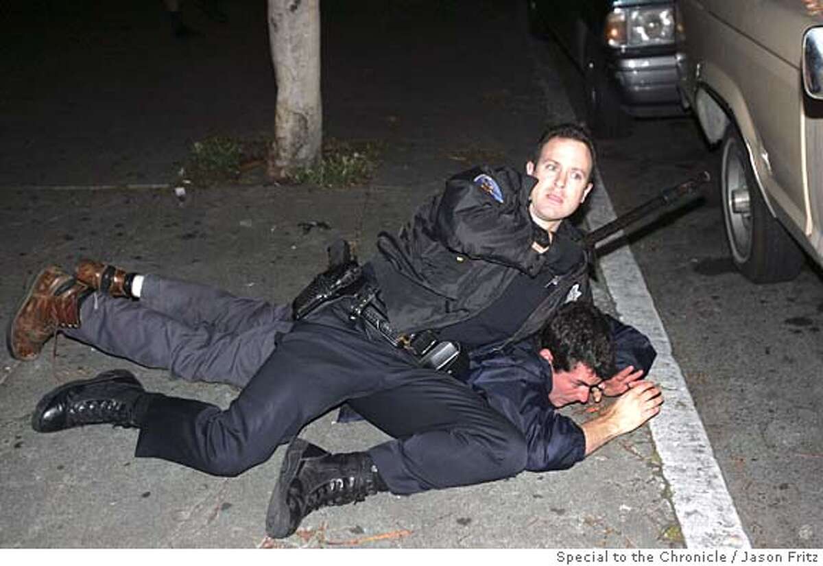 SFPD officer tackles a protester on 23rd street near Mission late Friday evening. Special to the Chronicle/ Photo by Jason Fritz (one-time use, phone 415-370-1660)