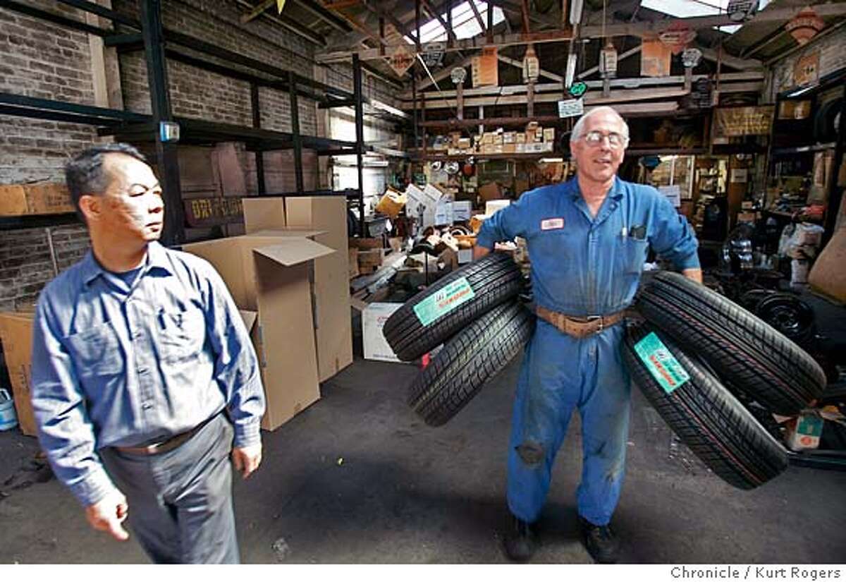 Tony Fung watches as John Rivelli takes some tire's as they are busy cleaning out their property. Tony Fung owner of Autohouse and John Rivelli the owner of Rivelli Tire .Both businesses are being evicted using eminent domain to pave the way for a giant housing complex. EVICT02_0119_kr.JPG 7/1/05 in Oakland,CA. KURT ROGERS/THE CHRONICLE MANDATORY CREDIT FOR PHOTOG AND SF CHRONICLE/ -MAGS OUT