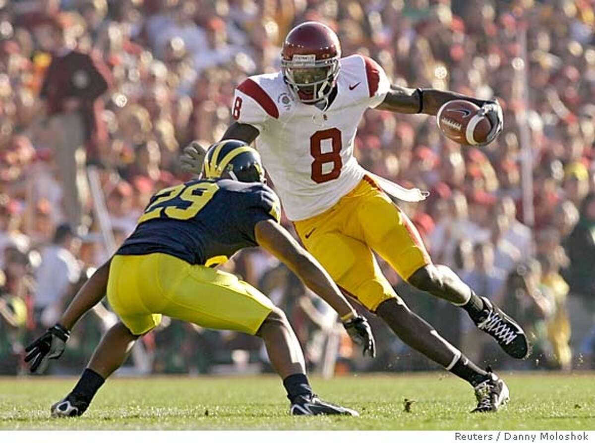 USC Trojans Dwayne Jarrett (8) gets the first down as he approaches the Michigan Wolverines cornerback Leon Hall in the first quarter of the 93rd Rose Bowl game in Pasadena, California, January 1, 2007. REUTERS/Danny Moloshok (UNITED STATES)
