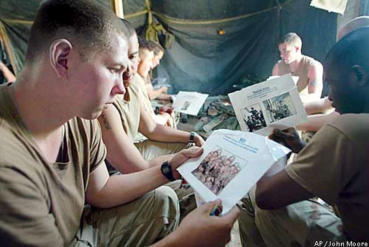 U.S. Army infantrymen from the A Company 3rd Battalion 7th Infantry Regiment, including Spc. Jaime Tielbar, 20, from Waukon, Iowa, left, are briefed on Iraqi forces during a squad-level meeting at their encampment in the desert of western Kuwait Monday, March 17, 2003. U.S. forces are awaiting orders for possible war with Iraq.(AP Photo/John Moore)