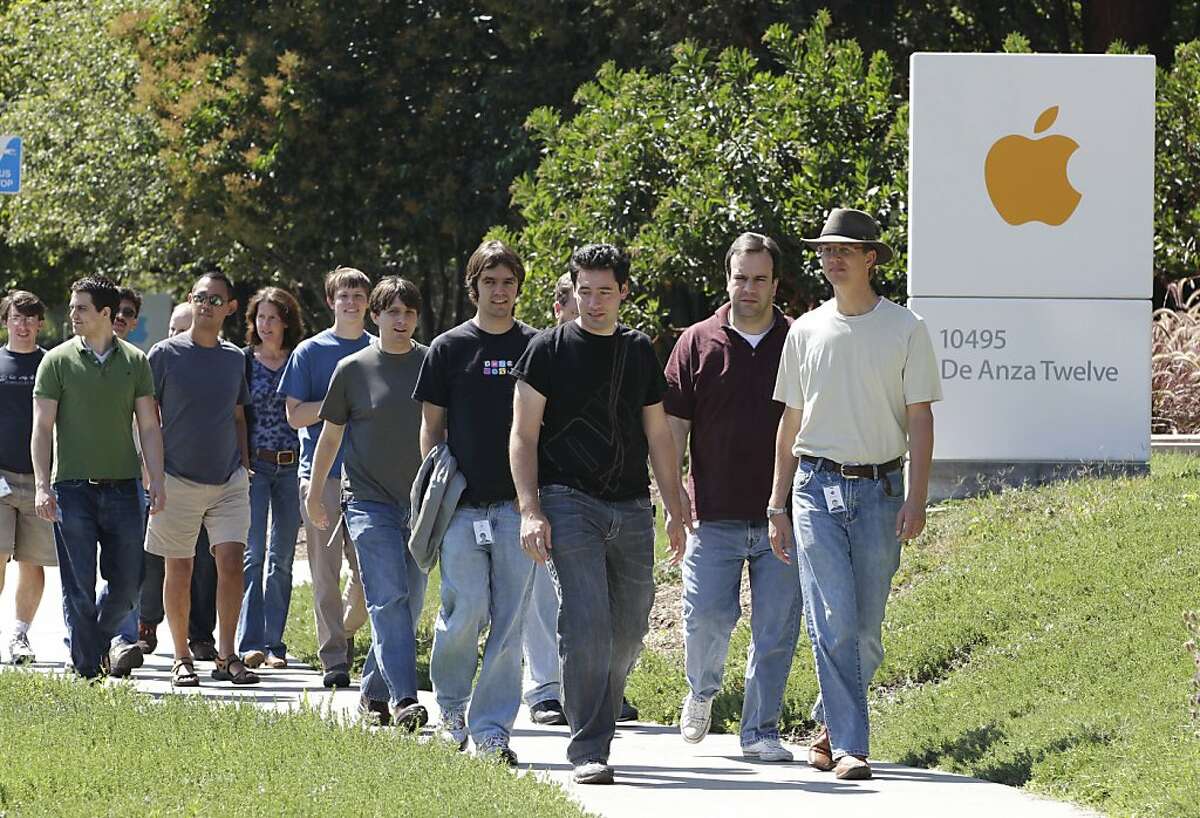 Apple employees walk between buildings at Apple headquarters in Cupertino.