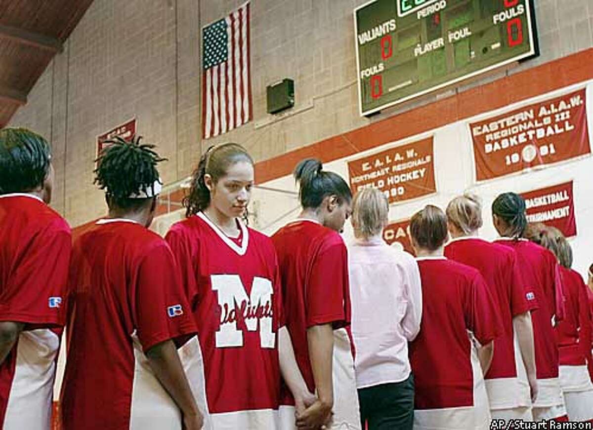 Toni Smith, third from left, turns her back on the American flag during the playing of the national emblem before a basketball game between Smith's team, the Manhattenville Valiants and Stevens Tech from New Jersey, at Manhattanville College in Purchase, NY., Sunday, Feb. 23, 2003. Smith, a forward guard for her team is protesting the impending war with Iraq. (AP Photo/Stuart Ramson)