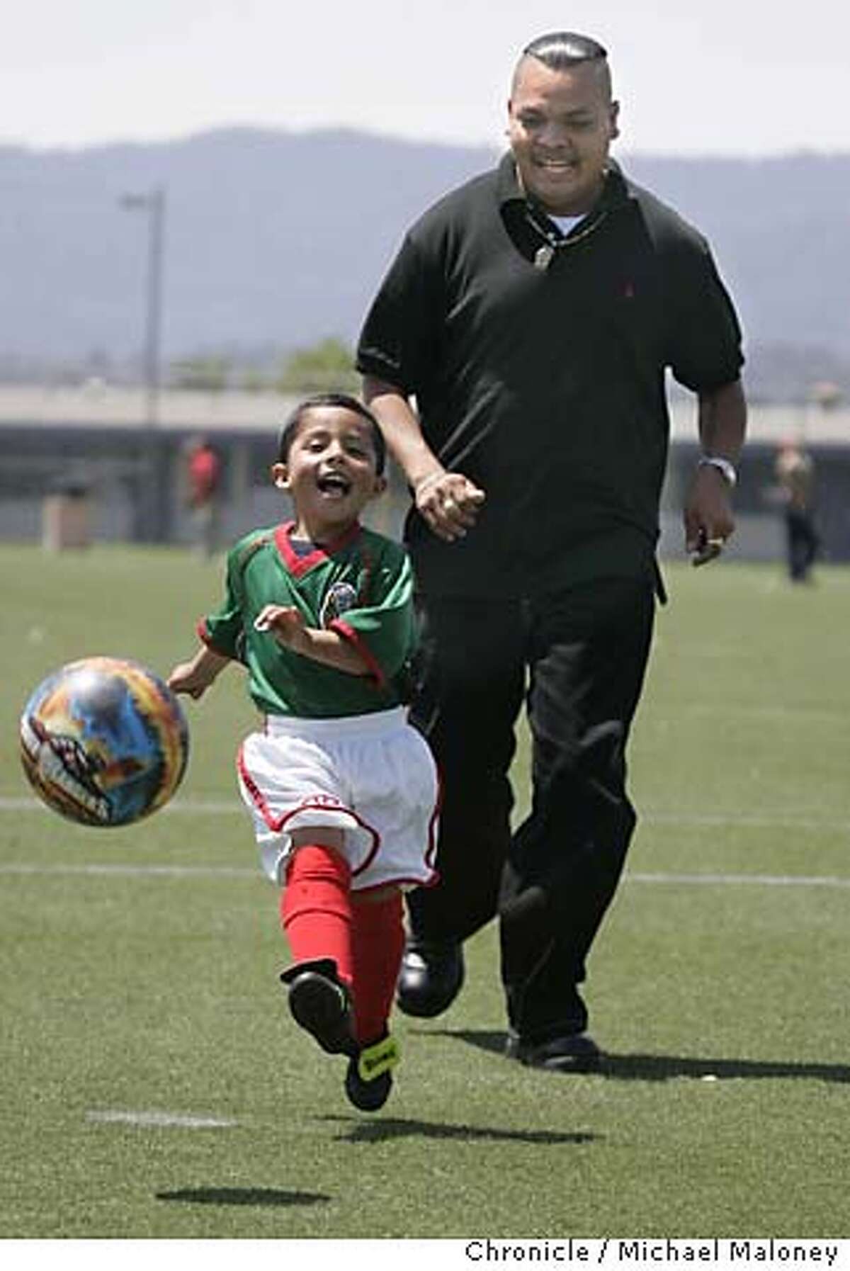 Three year old Osvaldo (cq) Garcia and his dad Juan Garcia practice soccer at the Hoover School soccer field in Redwood City. "Little Michoacan" in Redwood City, part of the unincorporated North Fair Oaks neighborhood is 90 percent Latino. The modest homes, sandwiched among neighboring apartments and duplexes, have a distinct Latino flavor. Photo by Michael Maloney / San Francisco Chronicle