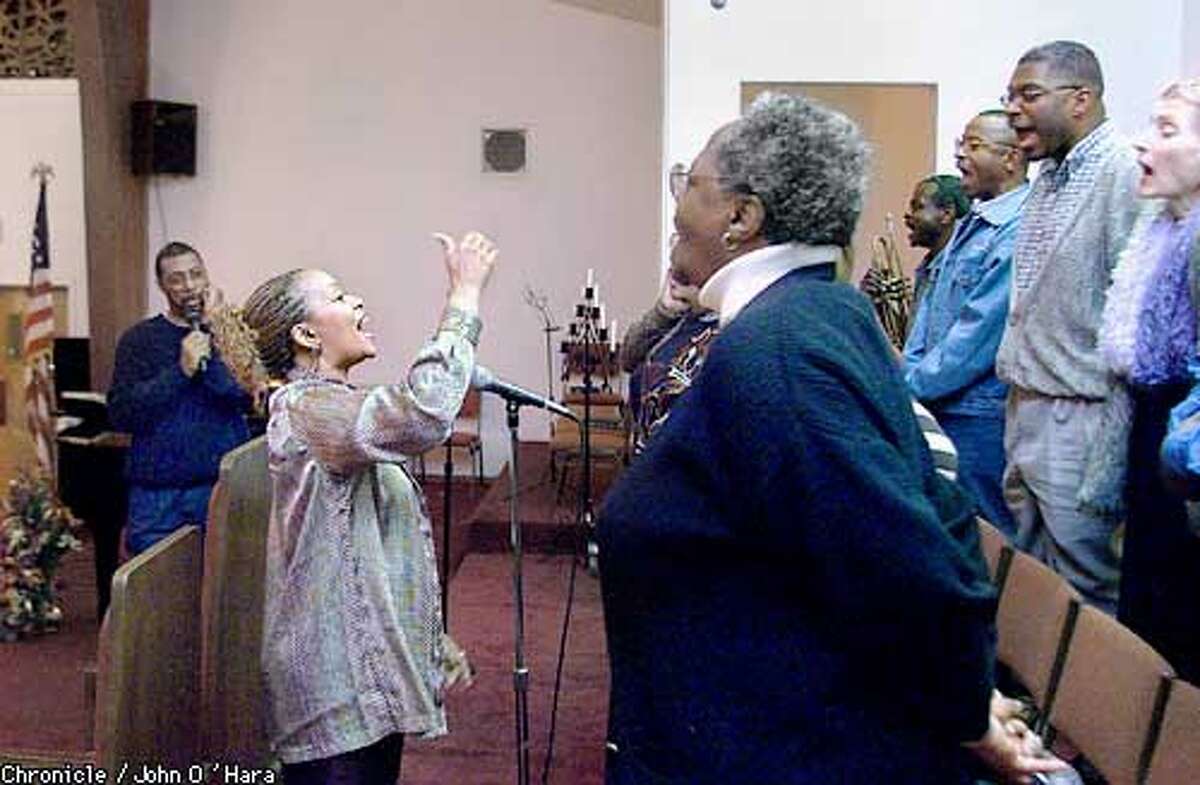 New Liberation Presbyterian Church, 1100 Divisidero St. SF Pastor Larry James (left) Pat James (wife and Choir leader, center) and John Williams Templeton (right top center) author of Black Money, talks at bible class about the evils of credit cards. Here Templeton practices with the choir before bible class. Photo/John O'hara