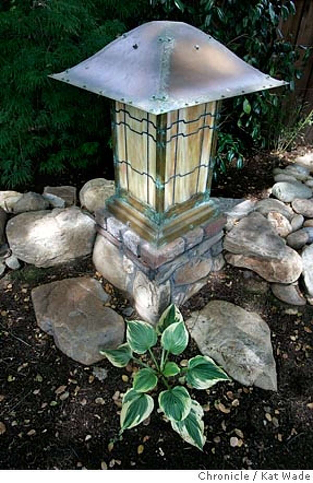 On 4/26/05 in Los Altos Debbie Segers recently designed garden including the subdued lighting of a stained glass and copper latern, a replica of a fixture at the Gamble House in pasadena, was designed to complement the craftsmen-style architecture of the bungalow home. Kat Wade/ The Chronicle
