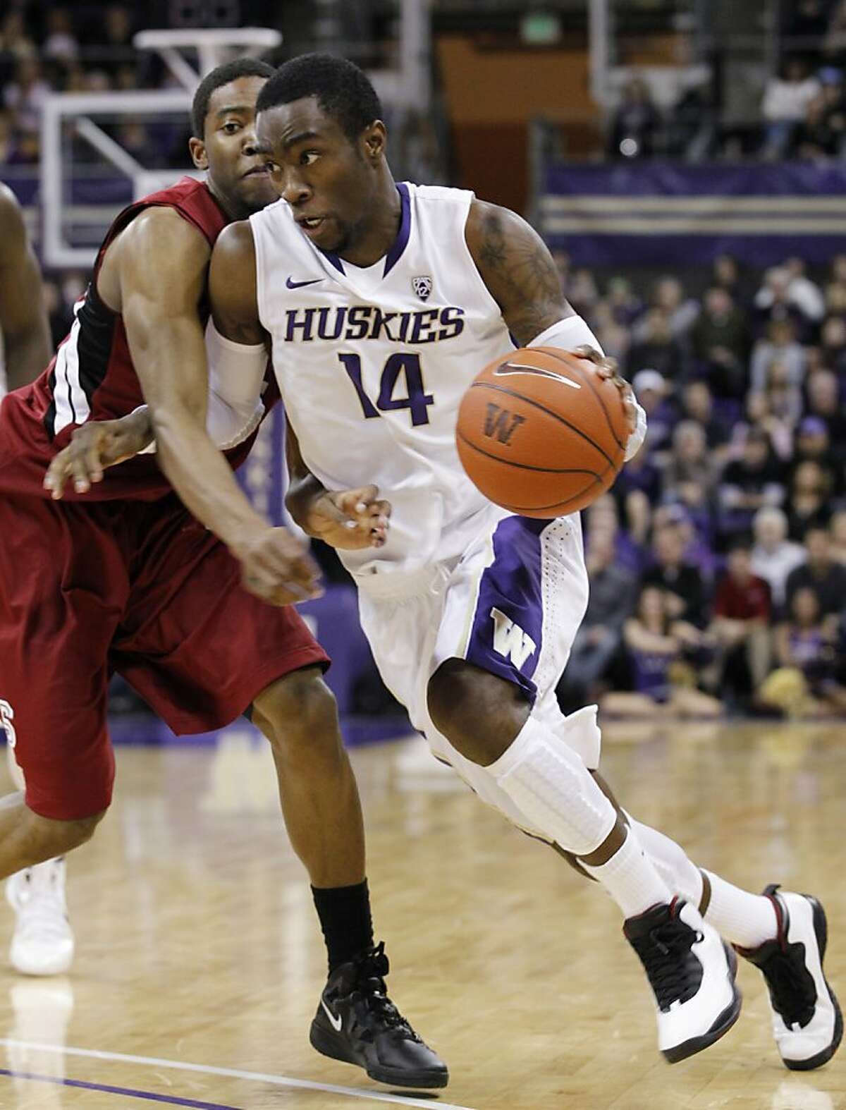 Washington's Tony Wroten (14) drives by Stanford's Chasson Randle in the second half of an NCAA college basketball game on Saturday, Jan. 21, 2012, in Seattle. Washington won 76-63. (AP Photo/Elaine Thompson)