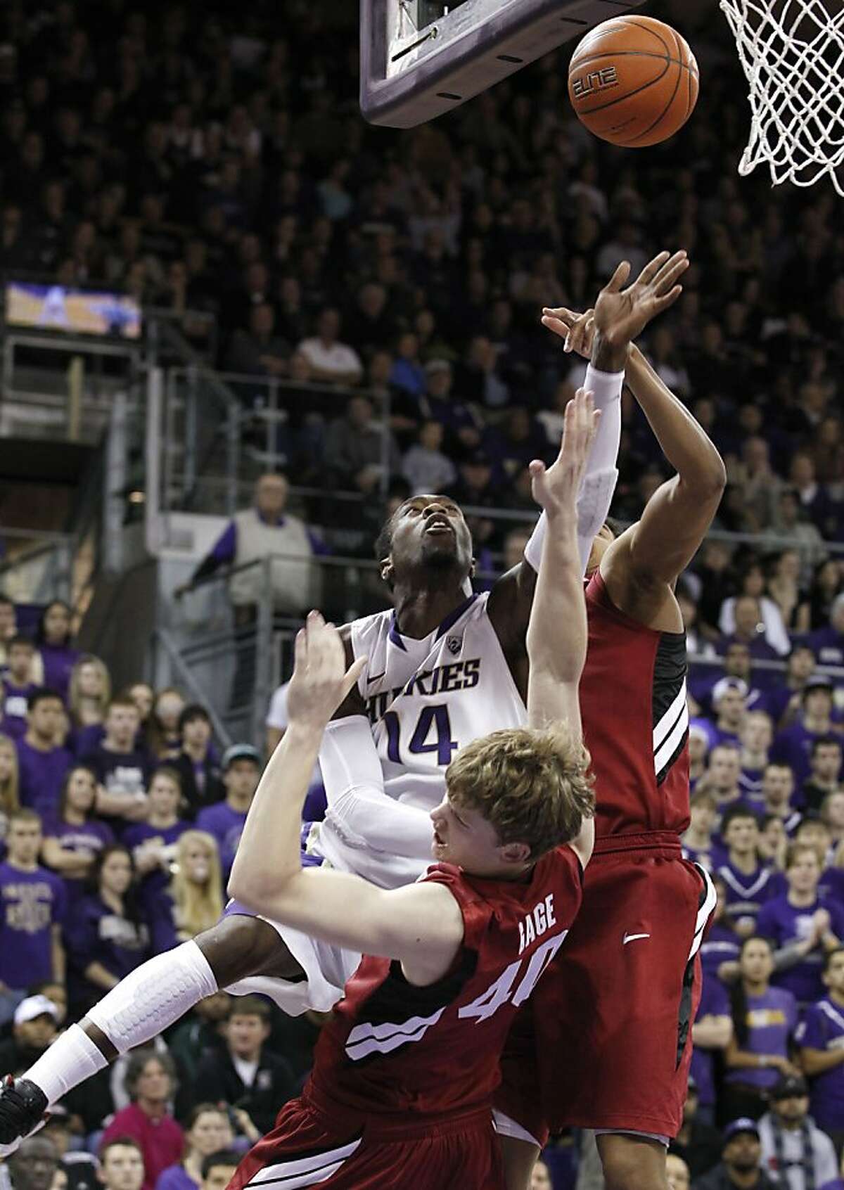 Washington's Tony Wroten (14) knocks down Stanford's John Gage on a drive in the second half of an NCAA college basketball game on Saturday, Jan. 21, 2012, in Seattle. Wroten was called for a foul on the play but scored a game-high 21 points. Washington won 76-63. (AP Photo/Elaine Thompson)