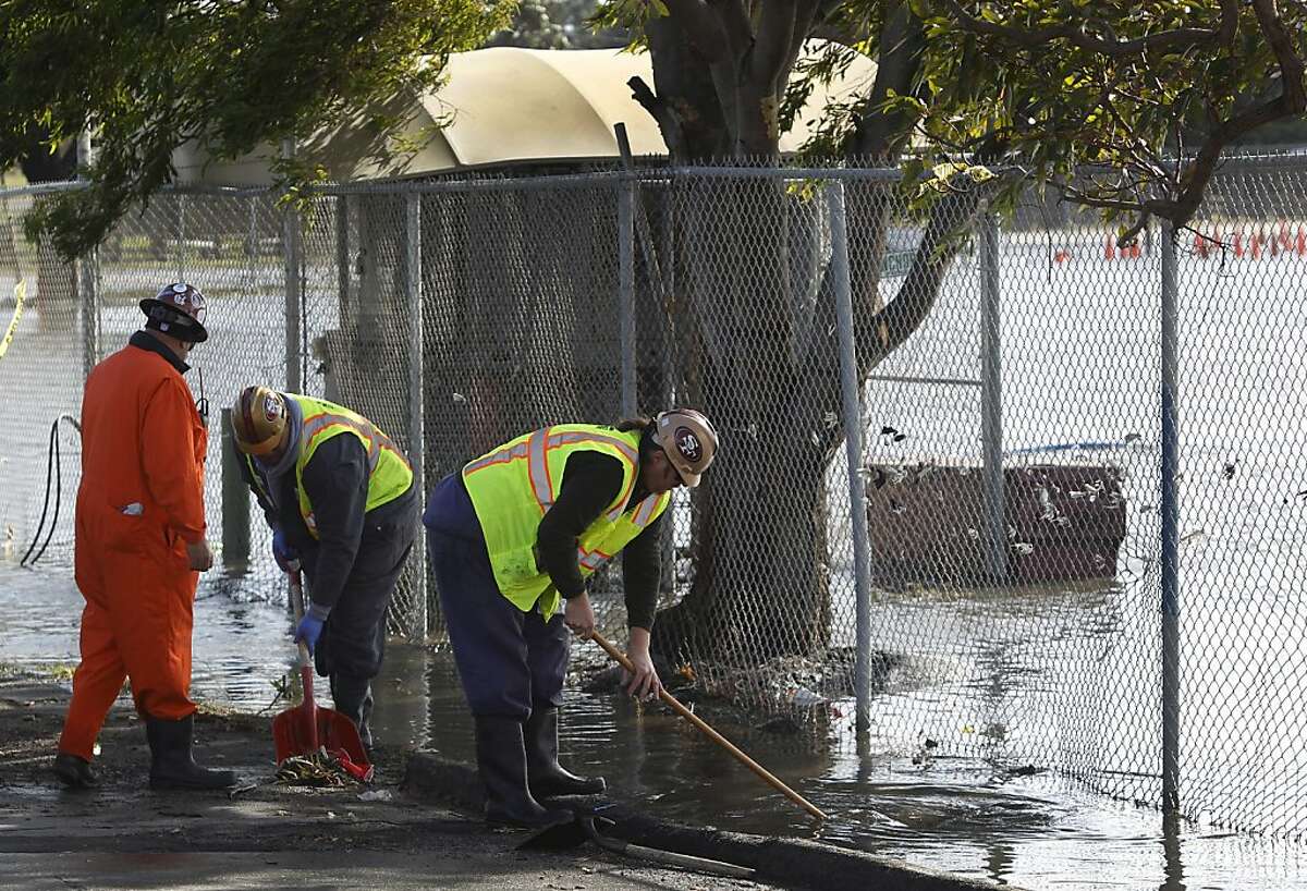 A Public Utilities Commission work crew clears debris after heavy overnight rain flooded the parking lot at Candlestick Park in San Francisco, Calif. on Saturday, Jan. 21, 2012. The crews will remain on site throughout the night and all day Sunday to make sure the lots are accessable by game time.