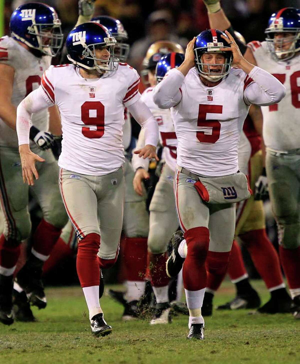Giants kicker Lawrence Tynes (9) and holder Steve Weatherford (5) celebrate after Tynes kicked the game winning field goal.
