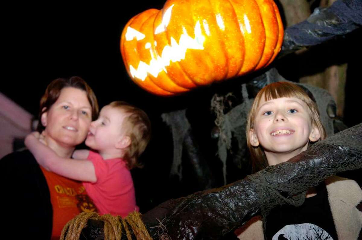 Alexandra Buss, 10, with mom the "Queen of Halloween" Karen Hasterok and daughter Quinn Hasterok, 2, flanked by the pumpkin king that has been more than one month in the making at their Old Greenwich home on Wendel Place Thursday evening, Oct, 29, 2009. The Hasterok Halloween fever has spread and they now do traditional decorating battle with neighbors led by Andrew Buss (unrrelated to Alexandra.) The verdict is still out on who won this year's contest.