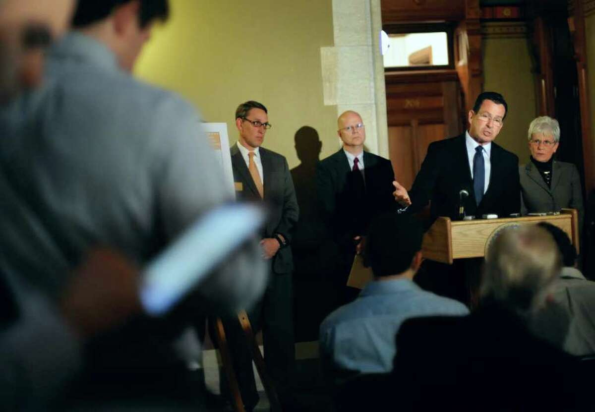 Gov. Dannel P. Malloy, at podium, speaks to the media at the Capitol as budget chief Ben Barnes, left, state Comptroller Kevin Lembo, second from left, and Lt. Gov. Nancy Wyman, right, look on in Hartford, Conn., Monday, Jan. 23, 2012. Malloy proposed a 20-year plan that will speed up state payments to Connecticut’s underfunded state employee pension system. The state’s pension fund is currently funded at less than 48 percent, ranking it among the worst in the nation. (AP Photo/Jessica Hill)