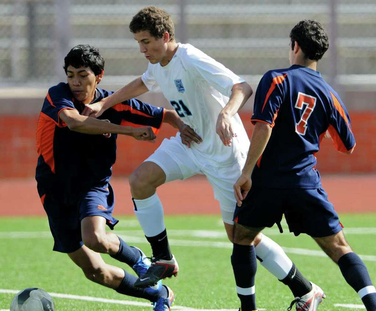 Brandeis' Pedro Torres (6) and Anthony Charbel (7) sandwich Johnson junior Jake Duvall (21) as they battle for control of the ball last weekend at Heroes Stadium. The Jags and Broncos tied 2-2 in a non-district match.