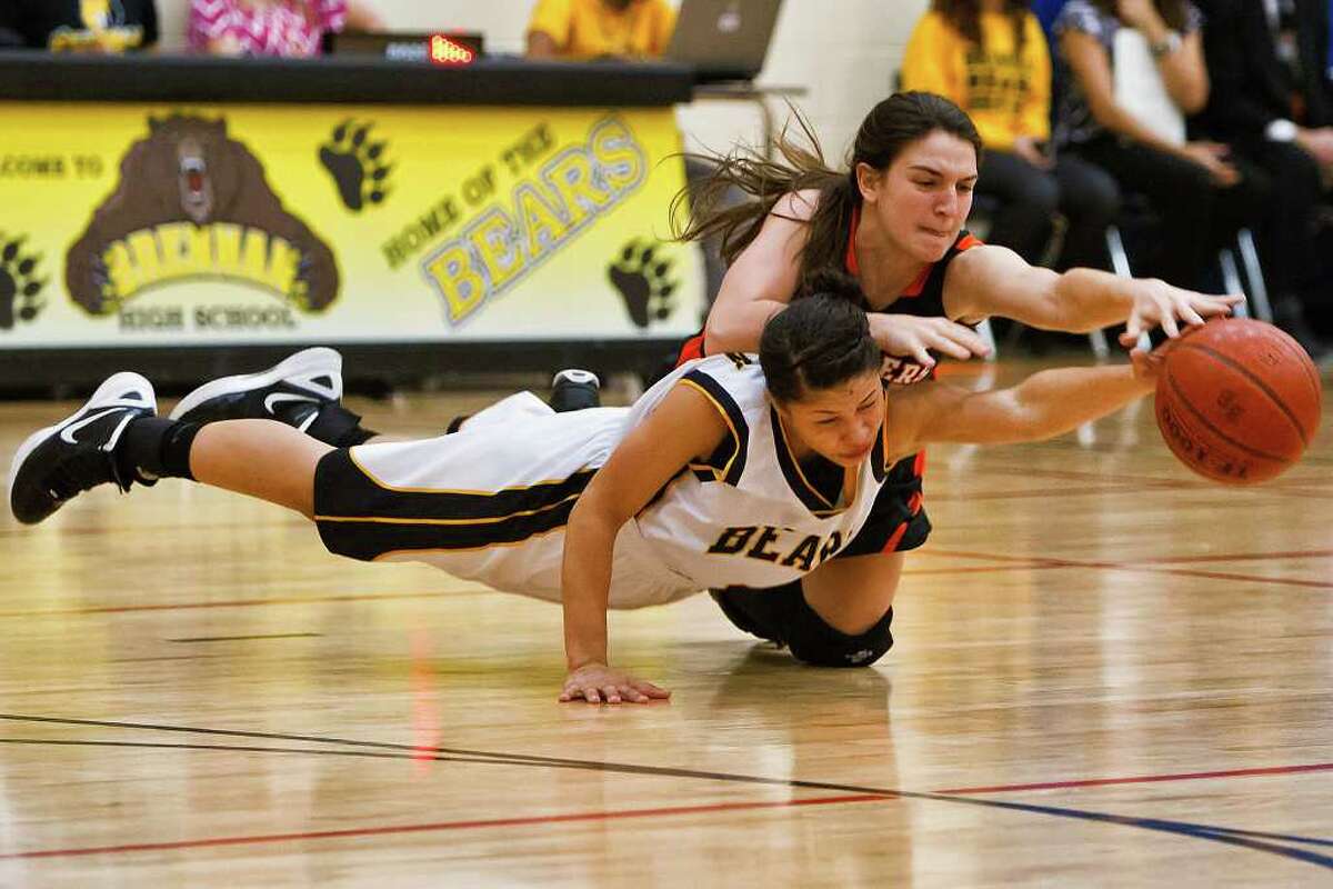 Brennan's Alyssa Crockett (below) fights with Medina Valley's Karlyn Williams for a loose ball during their game at the Brennan gym. The District 28-4A leading Bears bested the Panthers 47-40, with Crockett leading all scorers with 19. Photo by Marvin Pfeiffer