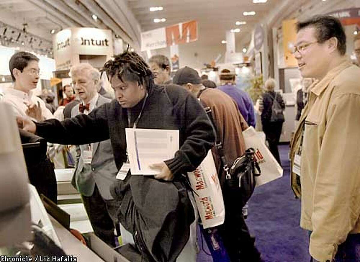 Macworld visitors at the Epson exhibit, looking at printers at the Macworld conference & expo in San Francisco's Moscone Center. (PHOTOGRAPHED BY LIZ HAFALIA/THE SAN FRANCISCO CHRONICLE)