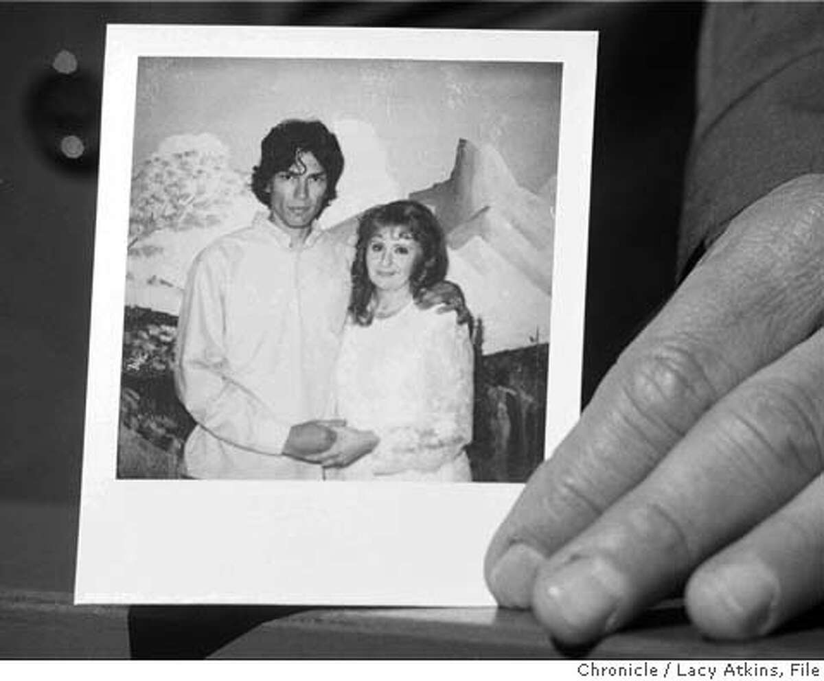 A wedding photograph is displayed to the media of the "Night Stalker" Richard Ramirez and his new bride Doreen Lioy, outside the gates of San Quentin Prison, Thursday Oct. 3, 1996, in San Quentin, Calif. The photograph was taken of the couple during the wedding ceremony inside the prison earlier in the day.(AP Photo/Lacy Atkins)