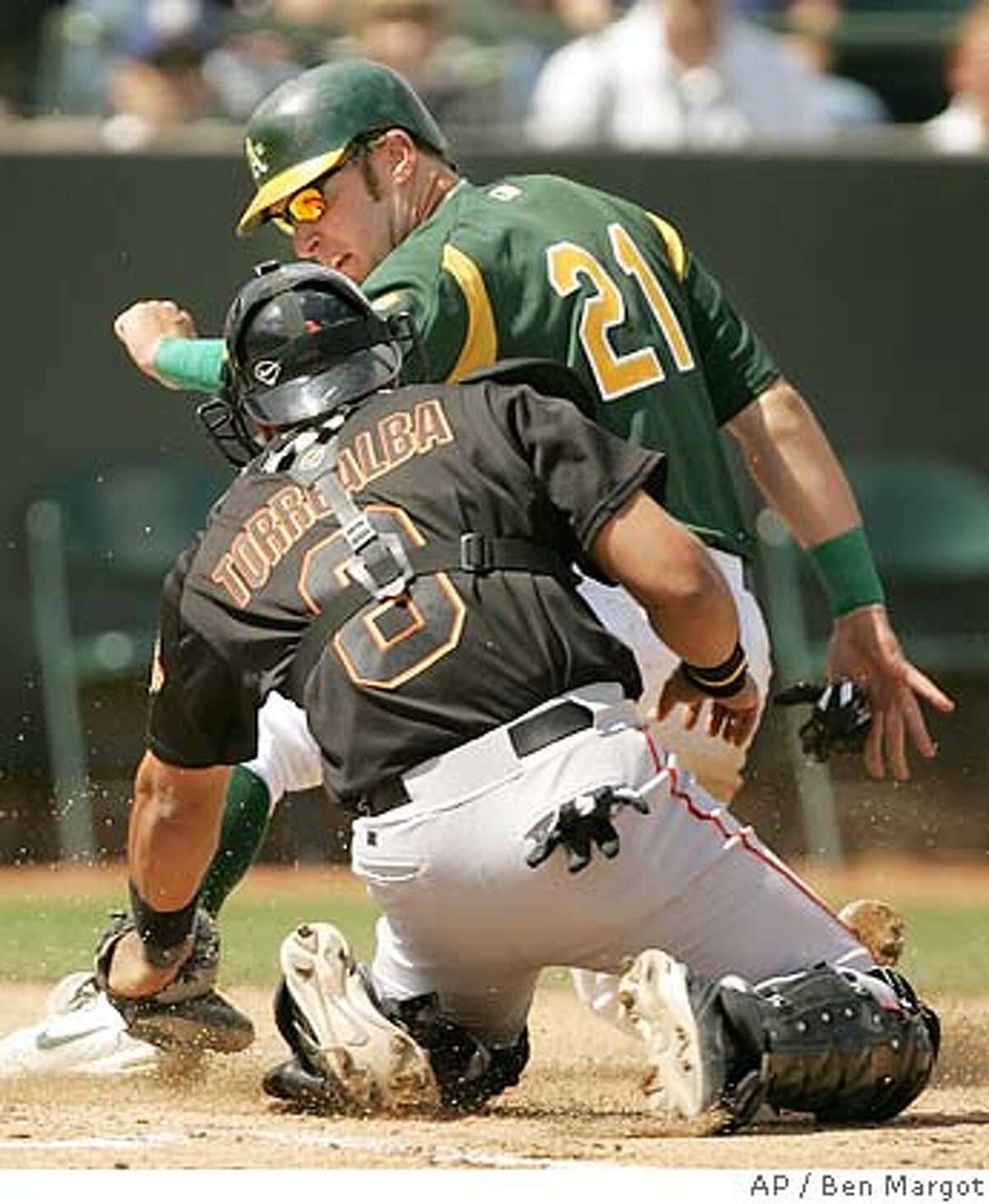 Oakland Athletics' Mark Kotsay (21) beats the tag of San Francisco Giants catcher Yorvit Torrealba to score in the first inning of a spring training game Sunday, March 20, 2005, in Phoenix. Kotsay scored on a single by teammate Erubiel Durazo. (AP Photo/Ben Margot)