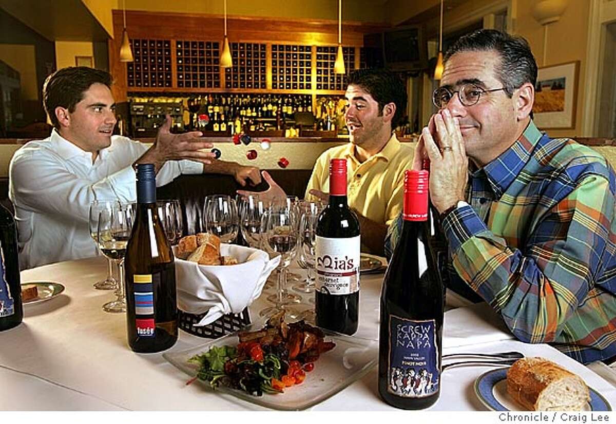 Don Sebastiani (far right) and his two sons, August, 24 (middle) and Donny, 27 (far left). They are in business together making innovative wines like "Screw Kappa Napa," which is sold in screw cap. Photo of Donny tossing screw caps to his brother August. Event on 9/1/04 in Sonoma. Craig Lee / The Chronicle