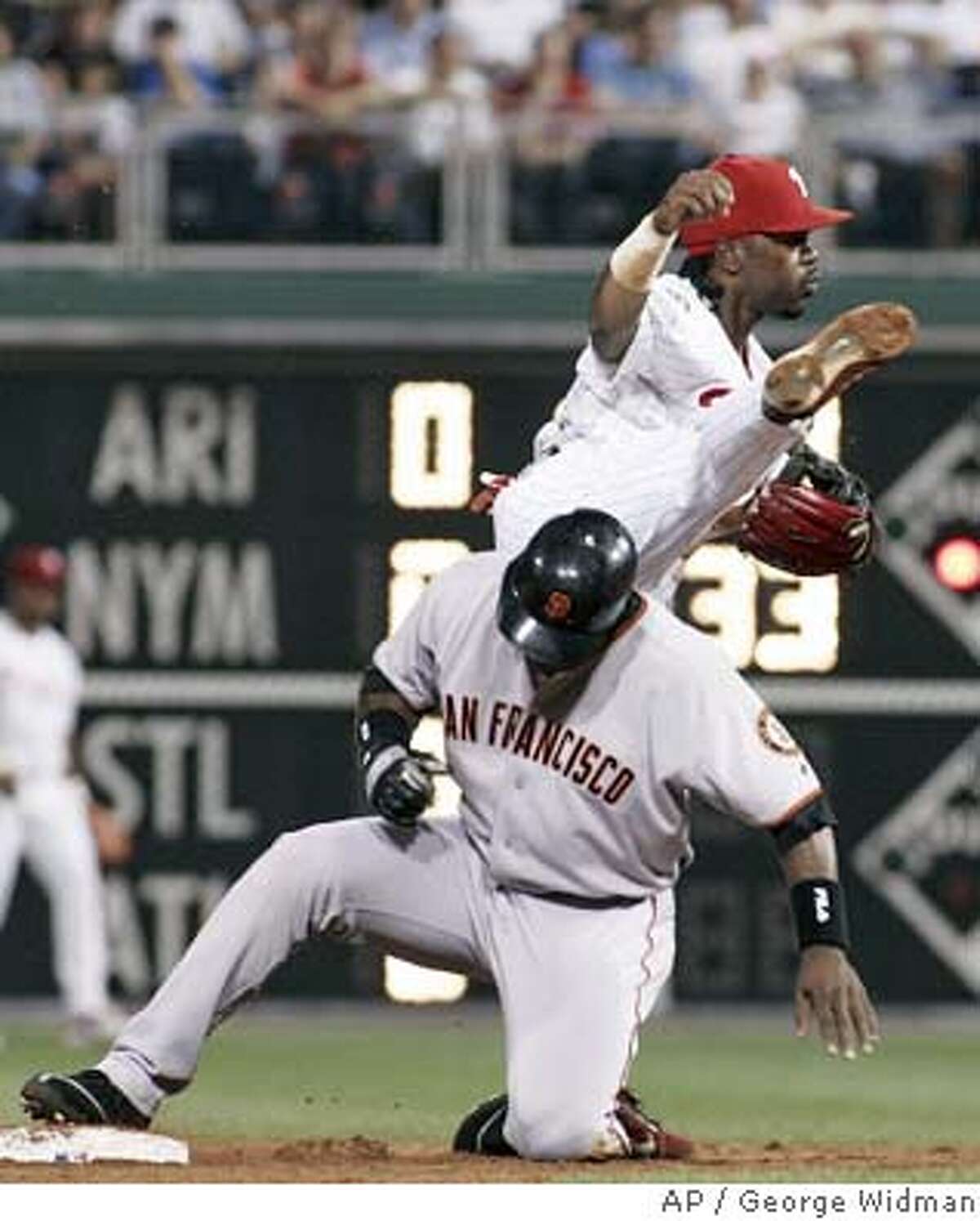 Philadelphia Phillies shortstop Jimmy Rollins gets a leg above San Francisco Giants' Barry Bonds, who was forced out at second base on a grounder by Michael Tucker in the third inning Friday, Aug. 13, 2004, in Philadelphia. J.T. Snow scored on the play. Tucker was safe at first. (AP Photo/George Widman)