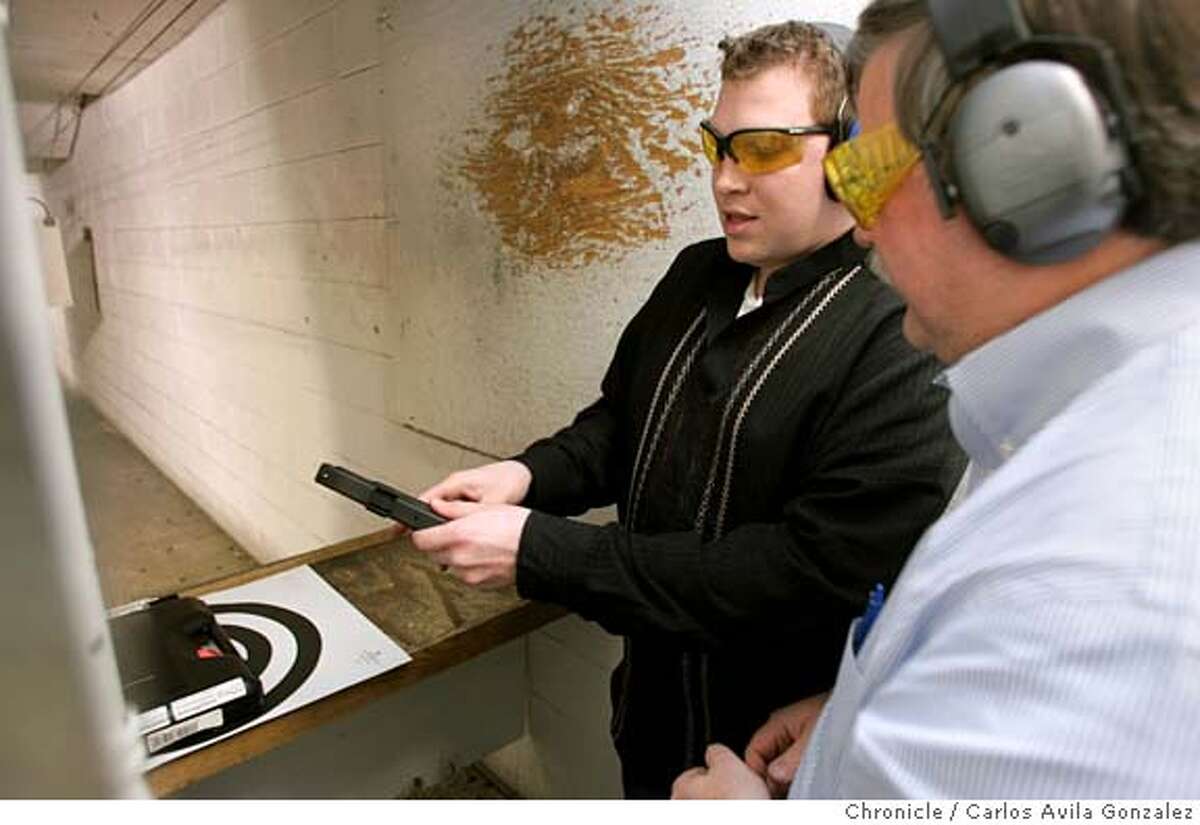 PISTOLS03_038_CAG.JPG Aaron Thomas, left, of San Francisco, and Richard Newell, right, of Walnut Creek, discuss a gun while target shooting at Jackson Arms Shooting Range in South San Francisco, Ca., on Tuesday, February 1, 2005. Against all stereotypes, this organization of gay men and lesbians advocates gun rights in San Francisco. They call themselves the Pink Pistols and they�ve found a new battle to fight now that the San Francisco supervisors want to make the city the second in the nation to ban the ownership of handguns. Photo by Carlos Avila Gonzalez / The San Francisco Chronicle Photo taken on 2/1/05 in South San Francisco, CA. MANDATORY CREDIT FOR PHOTOG AND SAN FRANCISCO CHRONICLE/ -MAGS OUT