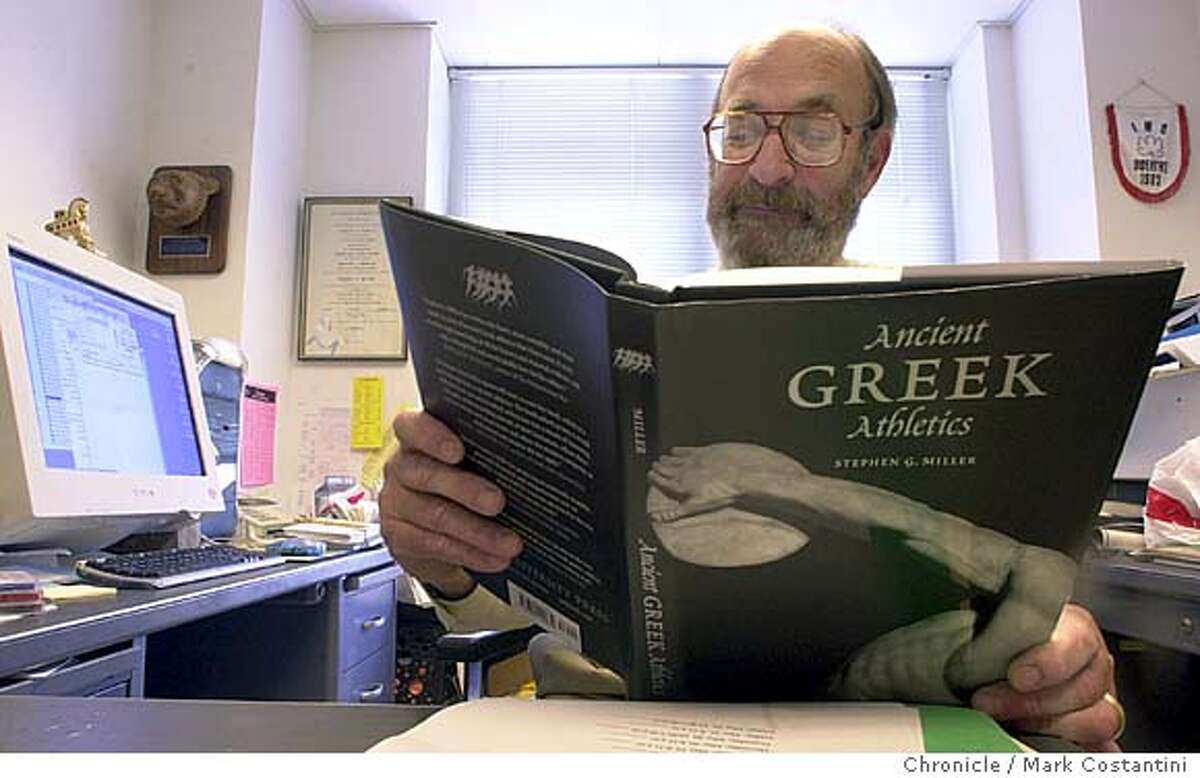 GREEK00_061.JPG Photo taken on 5/6/04 in BERKELEY. UC Berkeley classics professor Stephen Miller, in his office, reviews a copy of his recently published book. Chronicle Photo By Mark Costantini