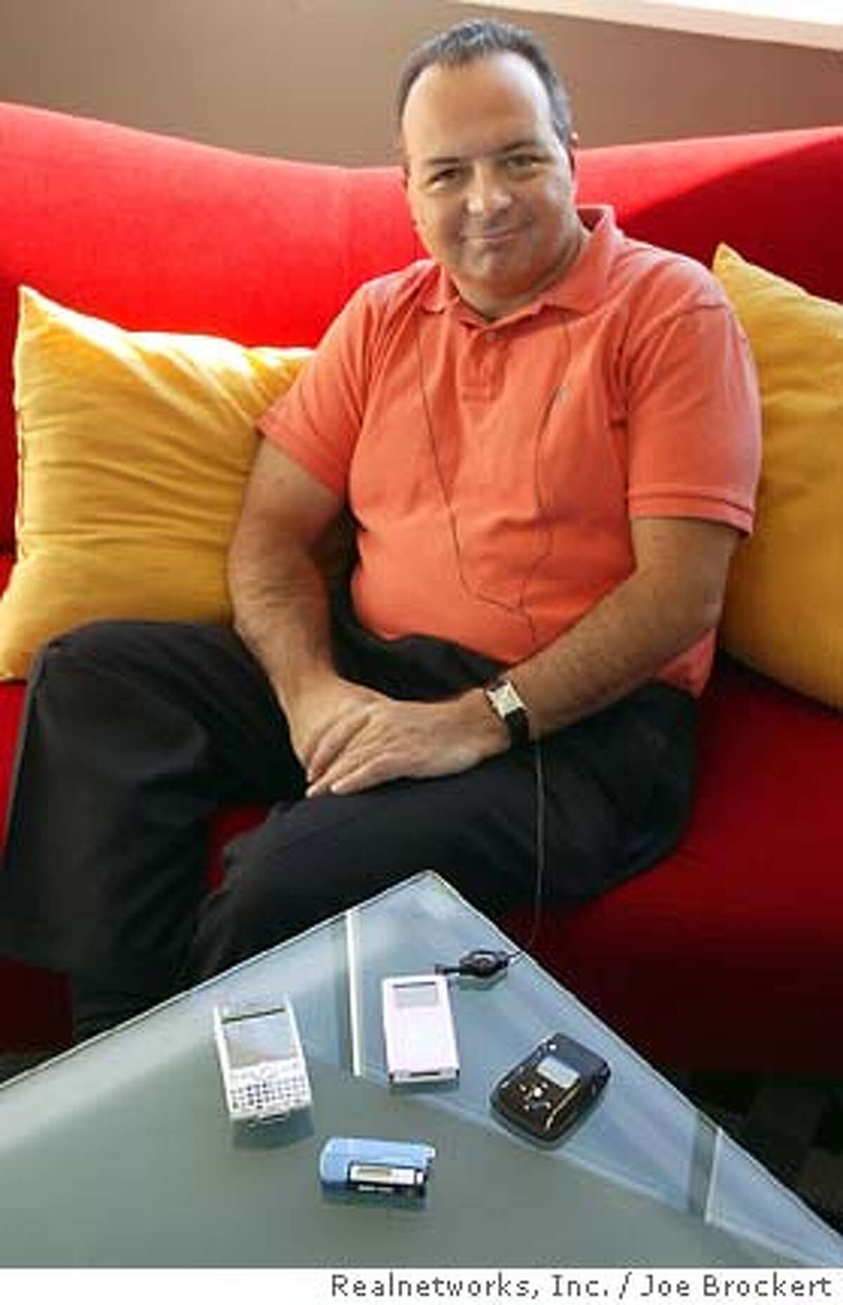 RealNetworks Inc. chief executive Rob Glaser relaxes Friday, July 23, 2004, listening to one of the company's new products at their headquarters in Seattle. RealNetworks Inc. says it has created technology that allows songs purchased through its online music services to be played on Apple Computer Inc.'s iPod player, just a few months after complaining that Apple was rebuffing attempts to form an alliance. In an interview Friday, Glaser said he did not know how Apple would react to the new technology. Apple, based in Cupertino, Calif., did not return numerous phone calls from The Associated Press seeking comment. (AP/WWP/Joe Brockert)