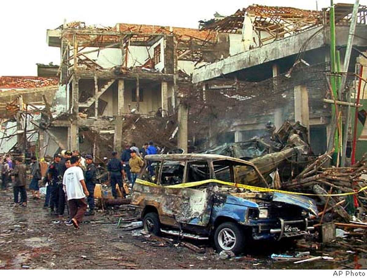 Police officers inspect the ruins of a nightclub destroyed by an explosion in Denpasar, Bali, Indonesia, Sunday, Oct. 13, 2002. Two bomb blasts, one of them exploded about 100 meters (300 feet) from the U.S. consular office, destroyed a nightclub on the tourist island, killing at least 58 people and injuring nearly 180 others, police and hospital workers said. (AP Photo/str) Ran on: 07-18-2004
