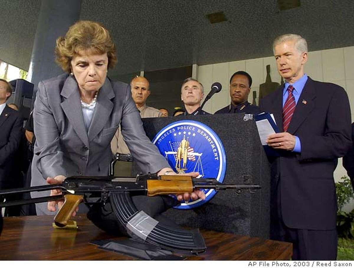 Sen. Dianne Feinstein, D-Calif., picks up an AK-47 at a speech about gun control with California Gov. Gray Davis, far right, Sheriff Lee Baca, back left, LAPD Chief William Bratton and Santa Monica Police Chief James T. Butts, second right, at a news conference in Los Angeles, Thursday, Aug. 21, 2003. The group urged Congress to re-authorize the assault weapons ban. (AP Photo/Reed Saxon) CAT w/RECALL