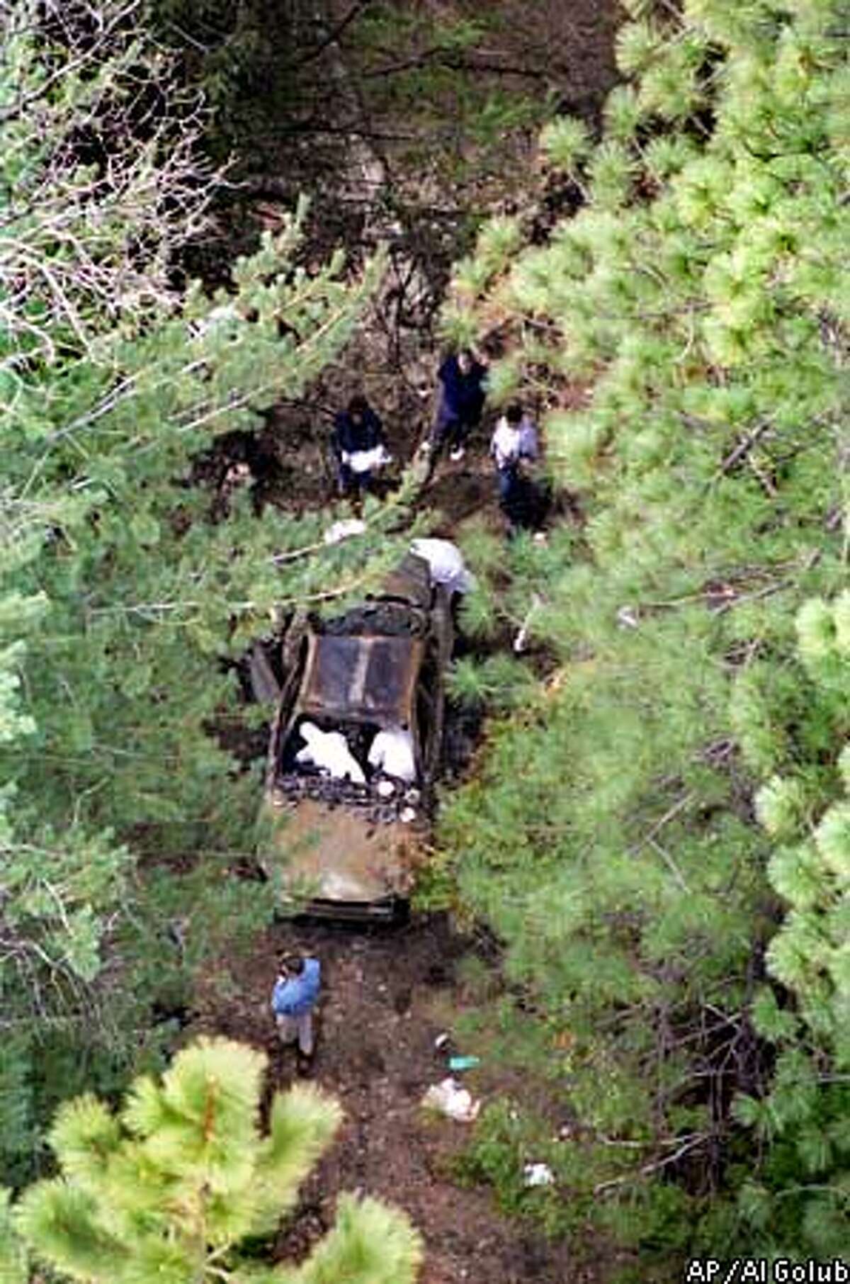 Investigators search the torched remains of Carole Sund's rental car for evidence near Sierra Village, Calif., in this March 19, 1999, file photo. Speaking in an off-camera jailhouse interview Monday, July 26, 1999, Cary Stayner, a motel handyman at the Cedar Lodge in El Portal, Calif., said he strangled Carole Sund and family friend Silvina Pelosso in their rented cabin at the Lodge and then abandoned the rental car with their bodies inside, returning two days later to burn evidence. (AP Photo/The Modesto Bee, Al Golub)